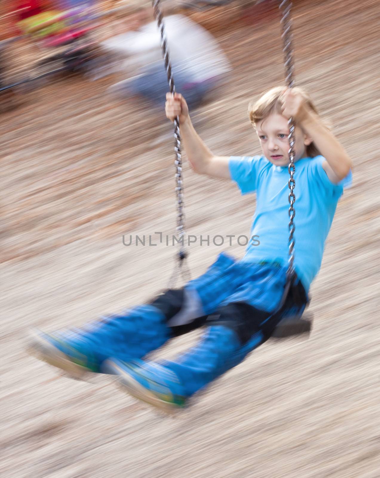 Boy on a Swing in the Playground by courtyardpix