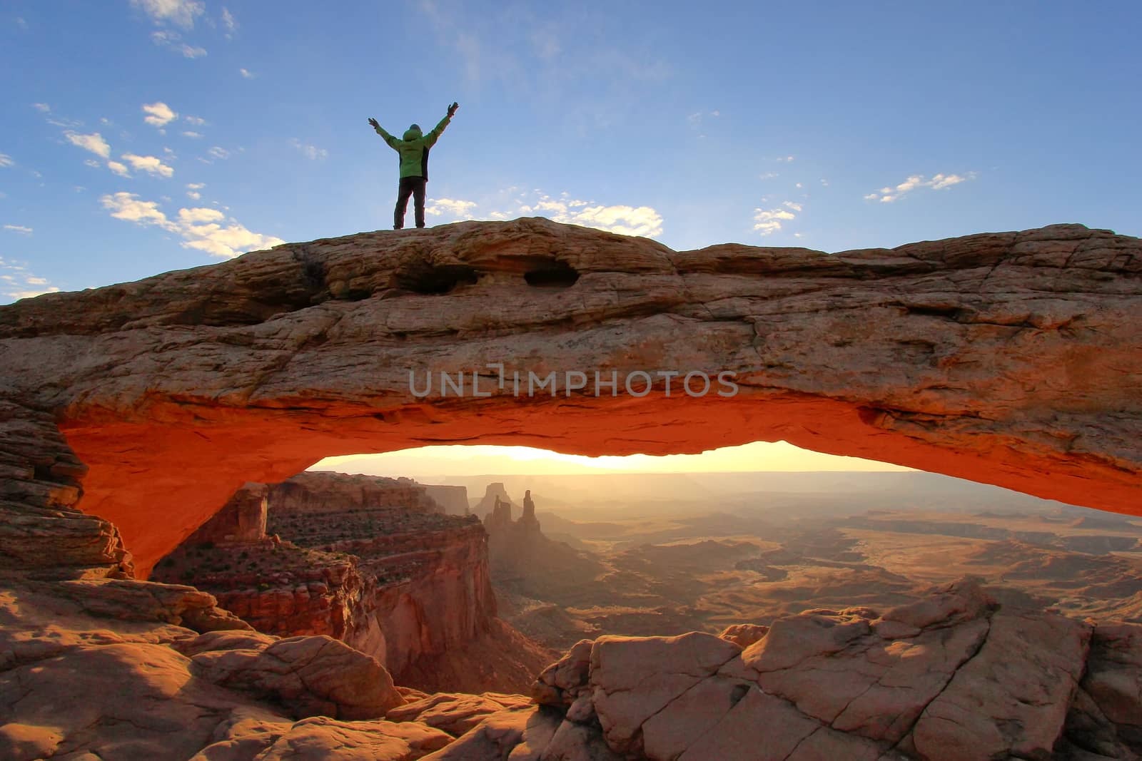 Silhouetted person standing on top of Mesa Arch, Canyonlands Nat by donya_nedomam
