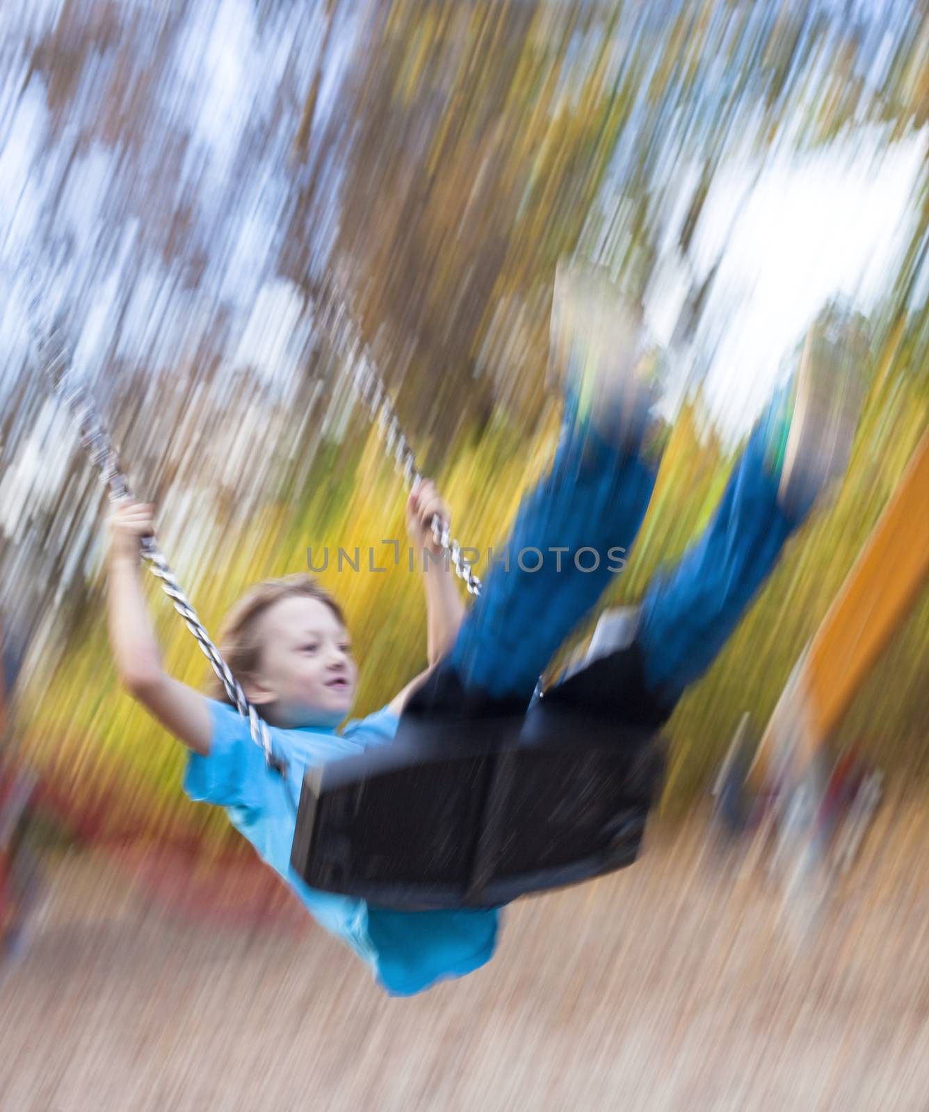 Boy on a Swing in the Playground by courtyardpix