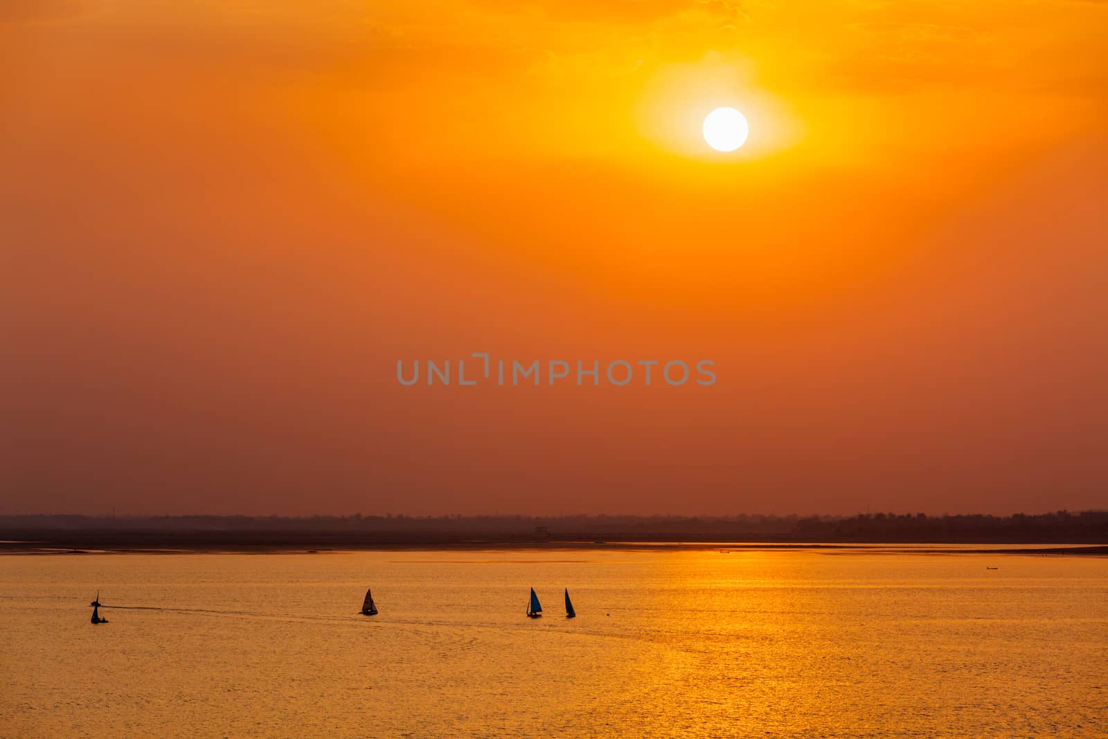 Yacht boats silhouettes in lake on sunset