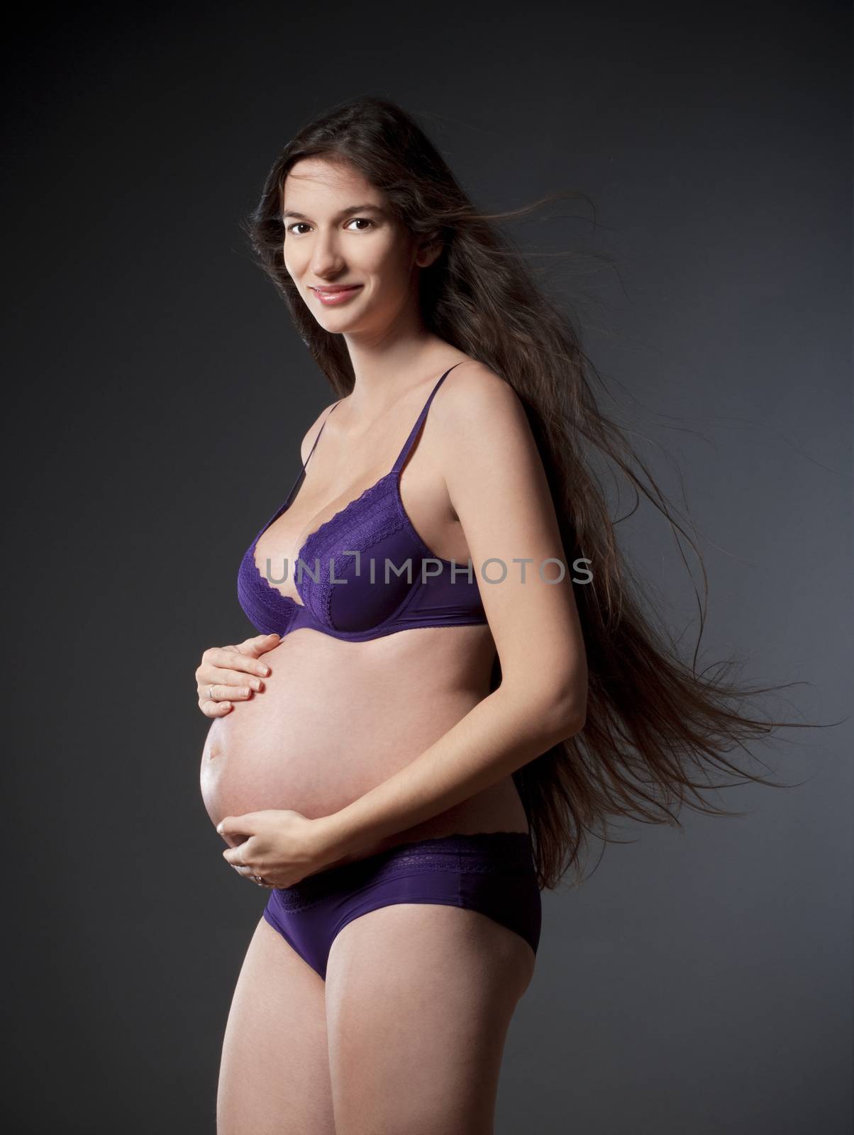 pregnant woman with very long brown hair in purple underwear