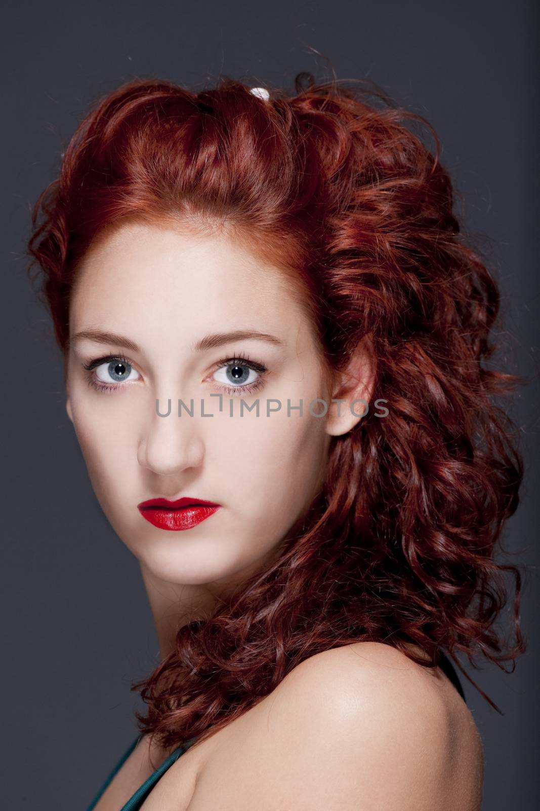 beautiful teenage woman with red hair looking - isolated on gray