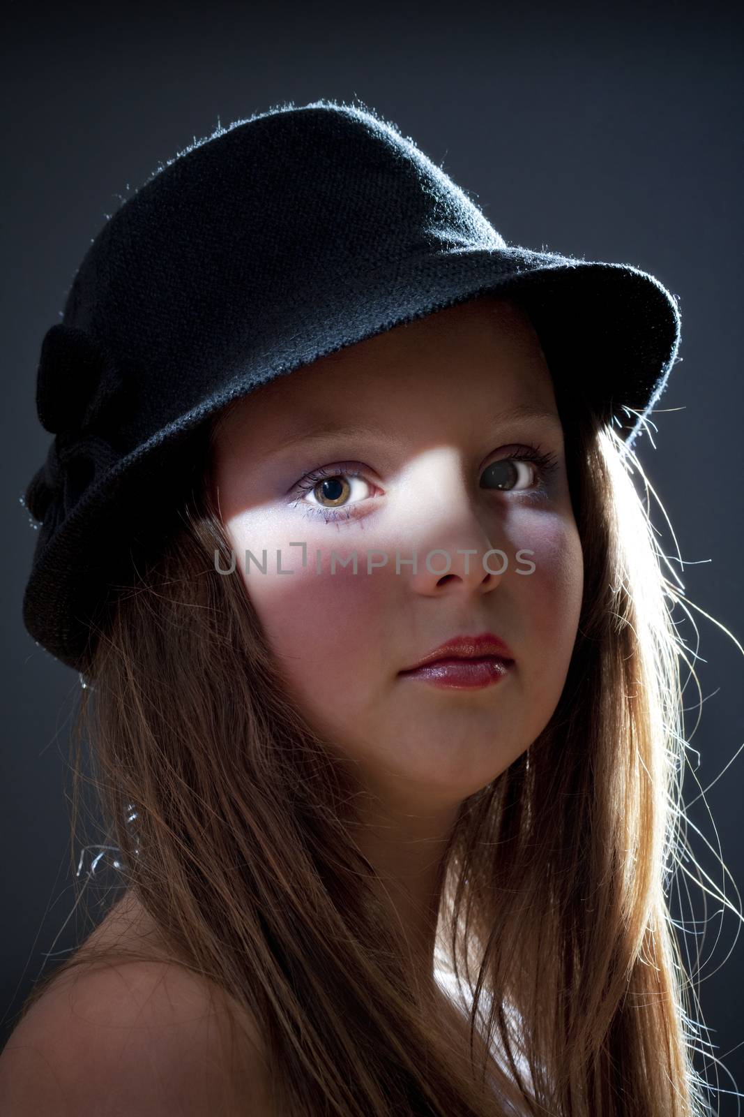 dramatic portrait of a twelve years old girl with hat