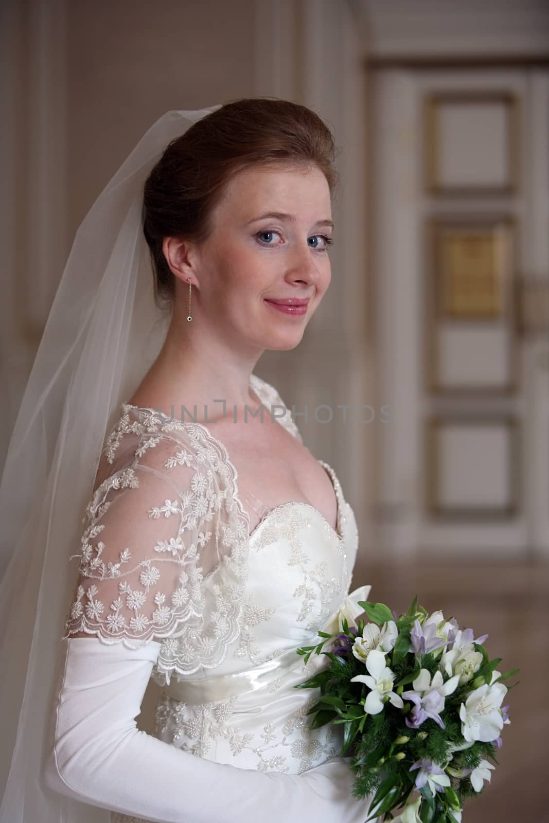 The beautiful bride with a bouquet in an interior