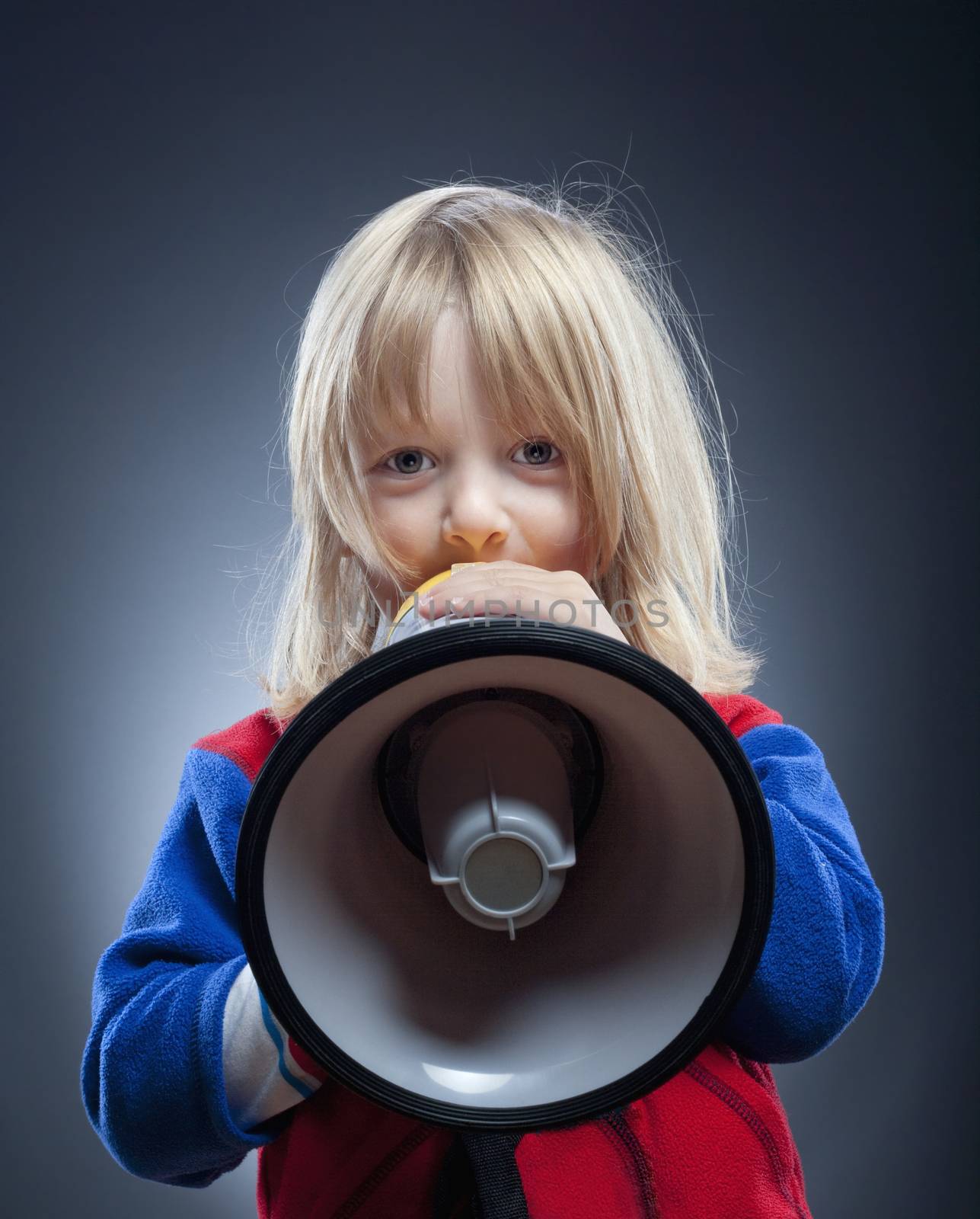 boy with long blond hair playing with a megaphone