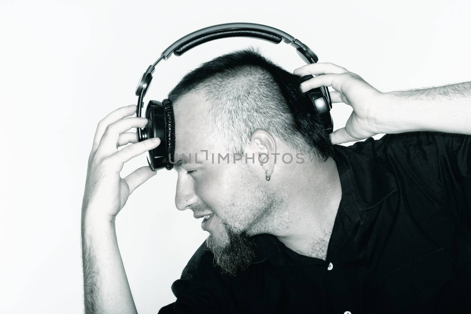 portrait of a man with beard holding headphones - isolated on white