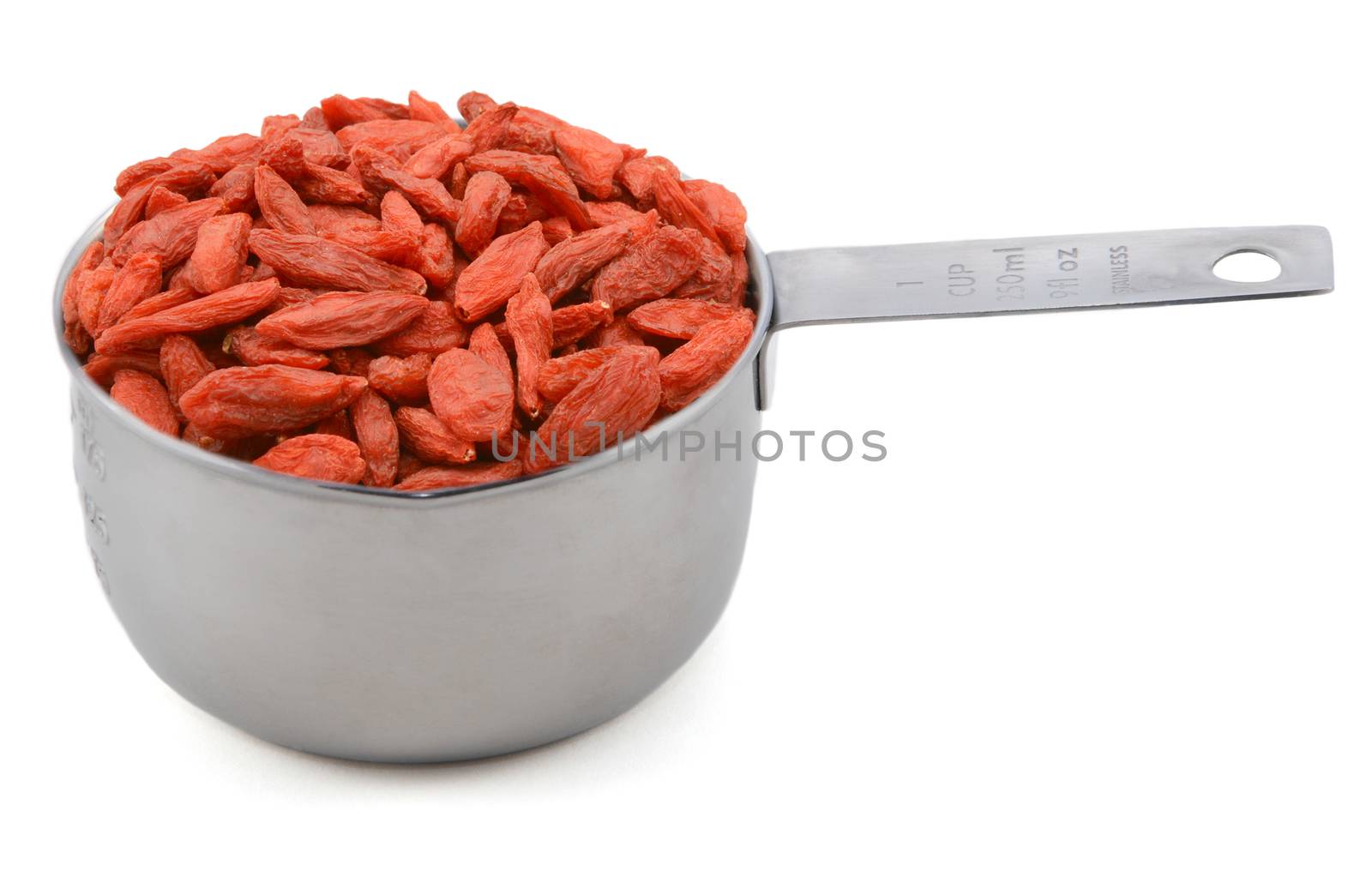 Red goji berries in an American cup measure, isolated on a white background