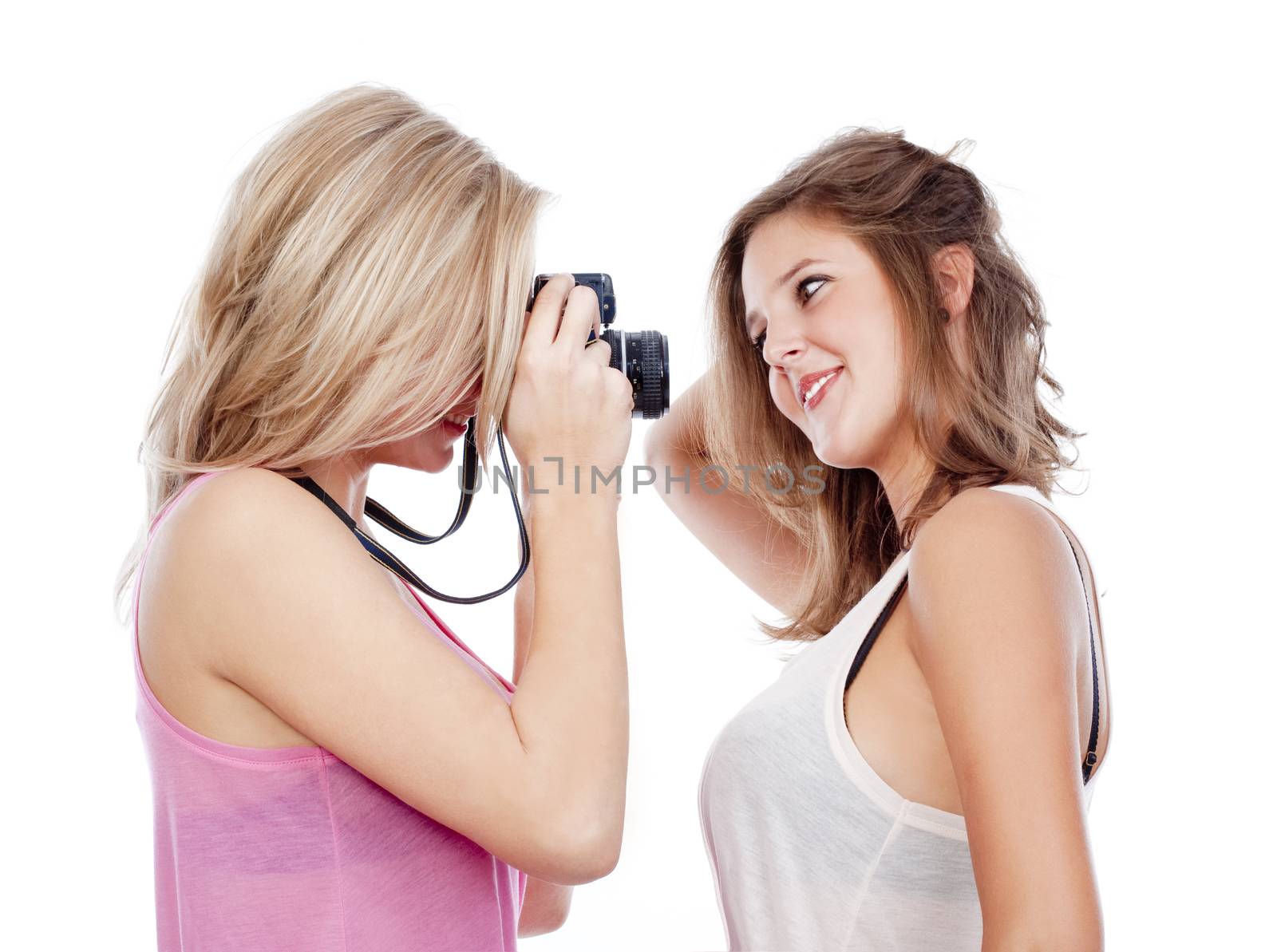 two young women taking pictures of each other - isolated on white