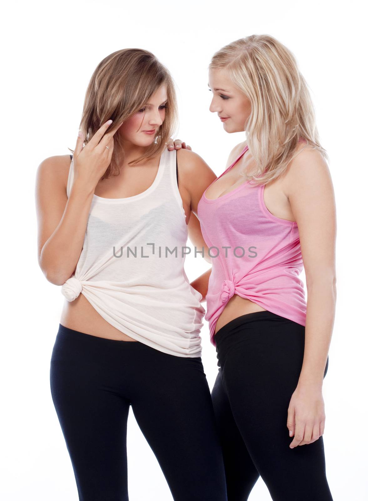 two young female friends standing talking- isolated on white