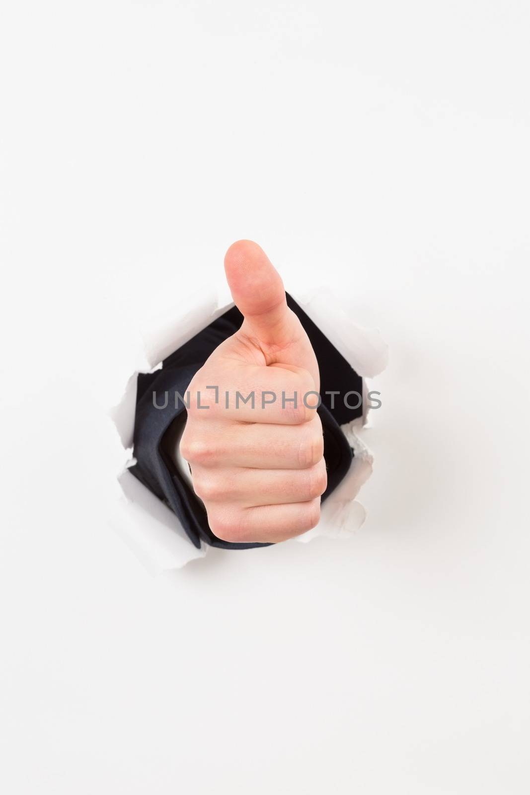 Thumbs up bursting through paper by Wavebreakmedia