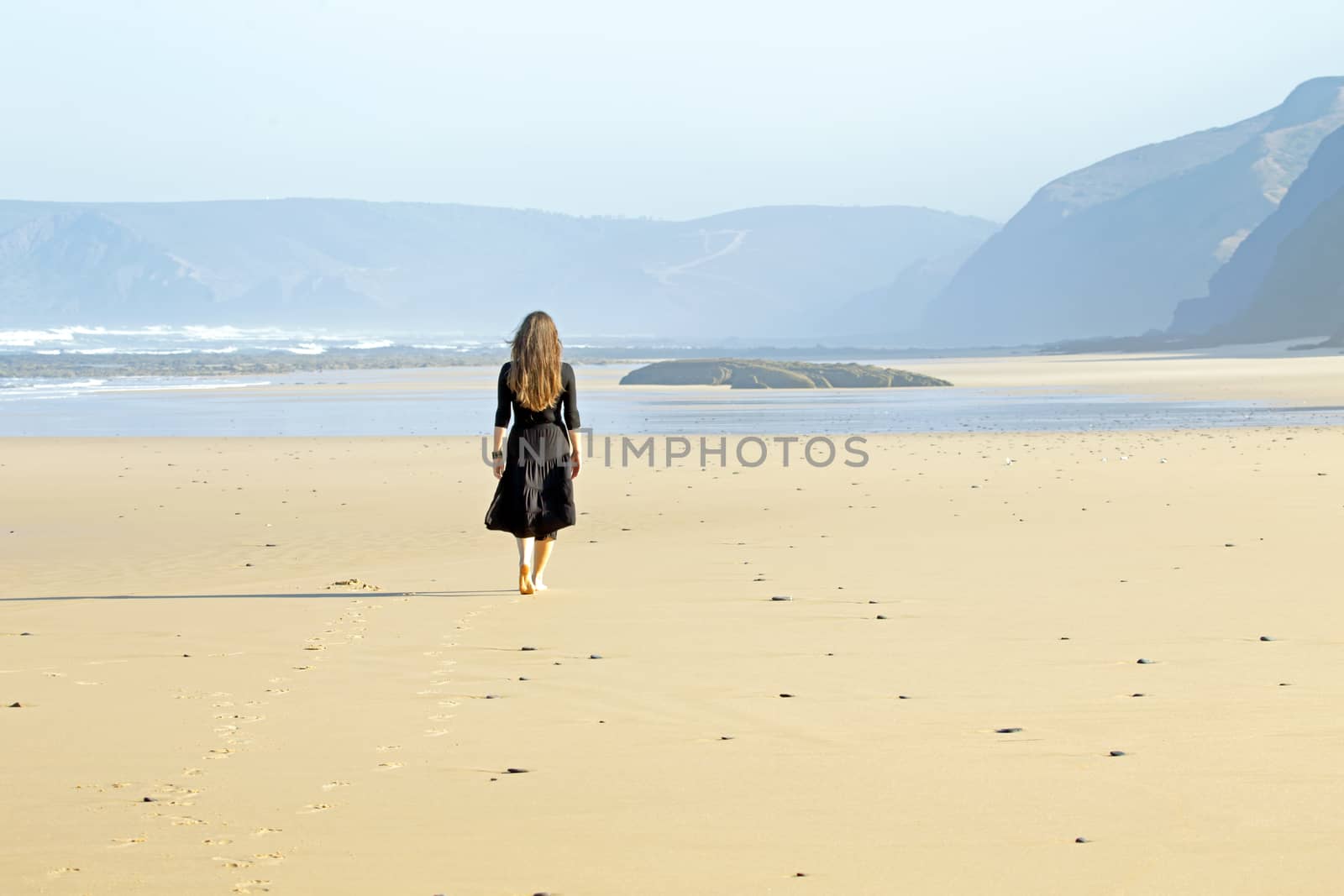 Lonely woman walking at the beach