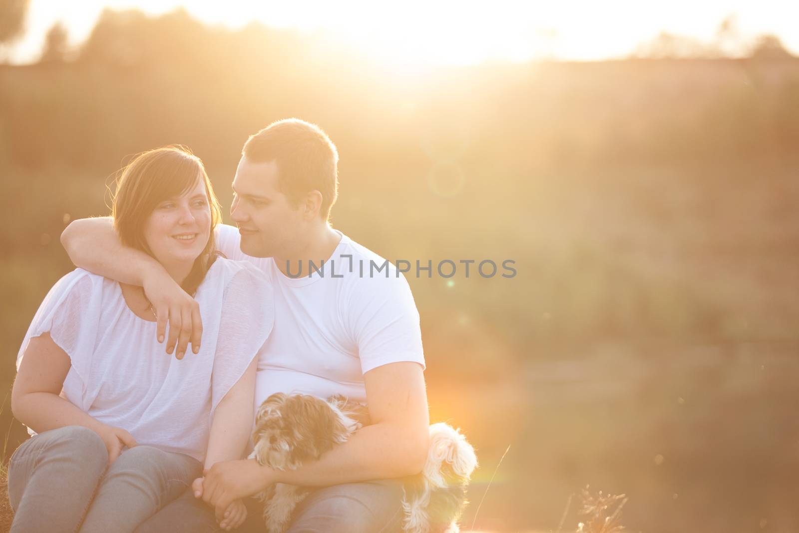 Young couple and puppy in sunlight by DNFStyle