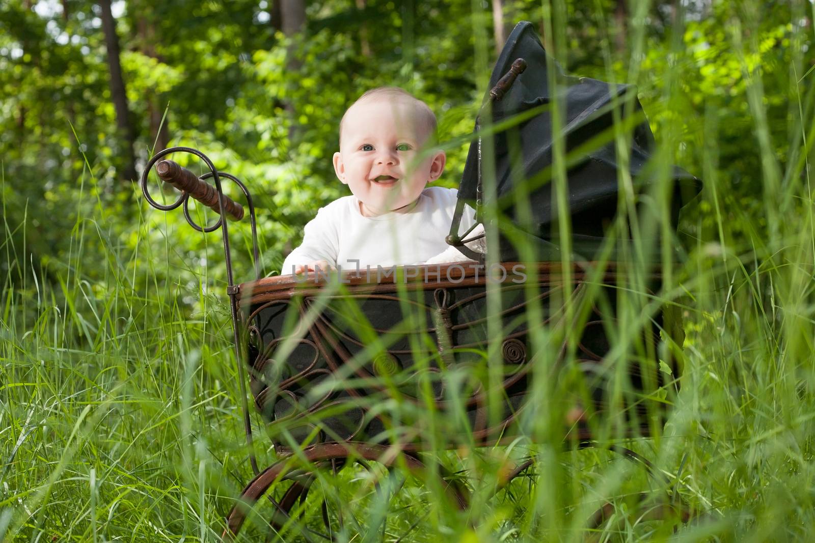 Baby girl is sitting in a vintage pram