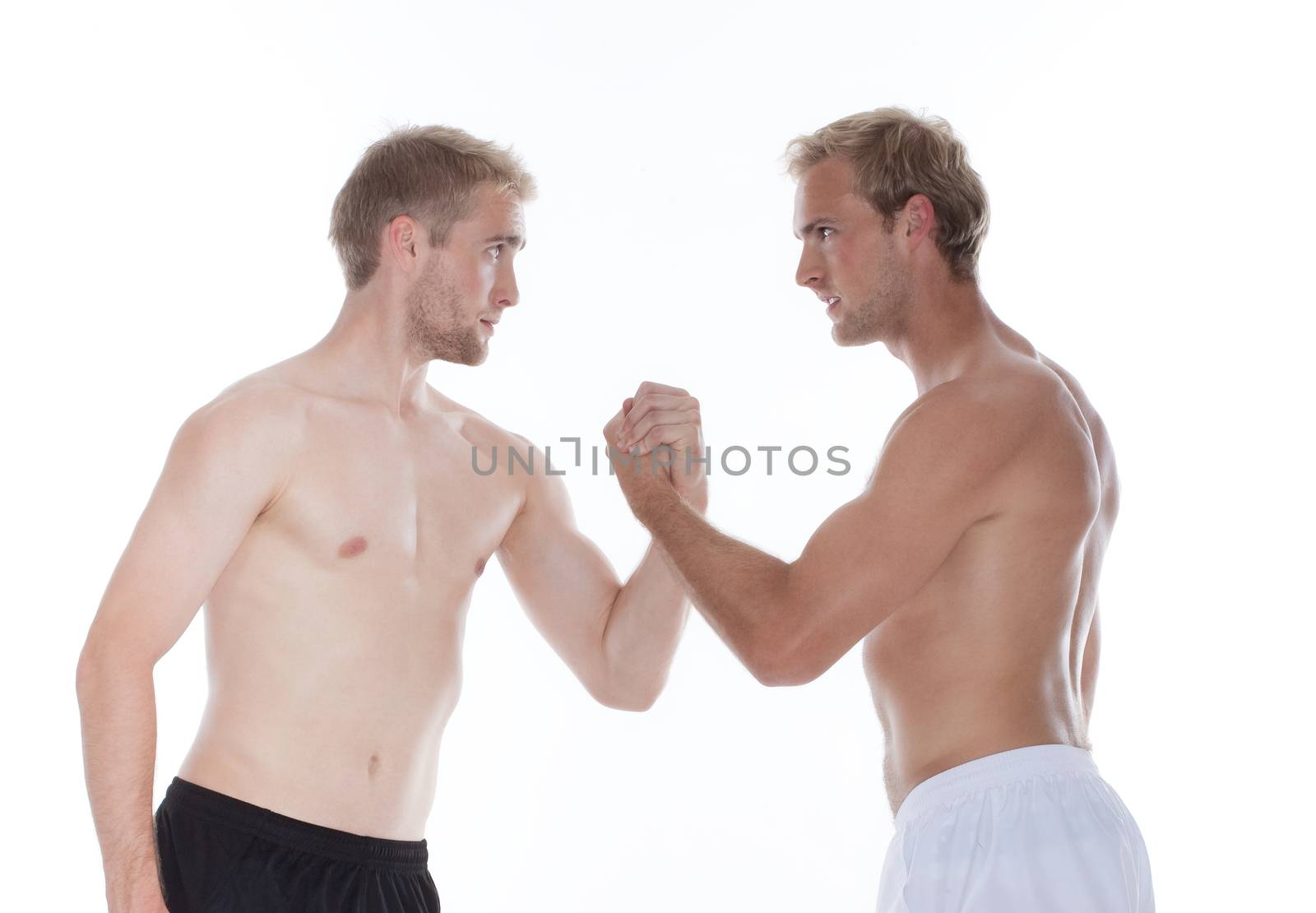 two young men in shorts wrestling - isolated on white