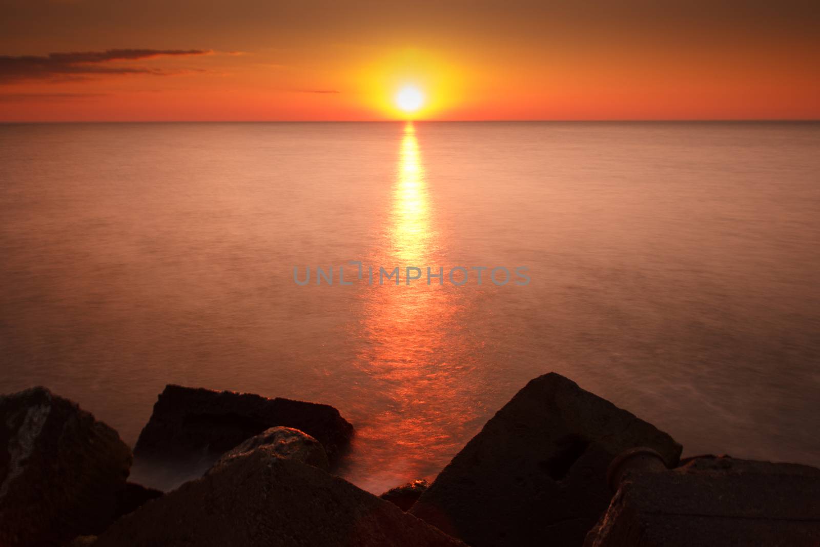 A beautiful sunset sight by the sea with blocks of stone