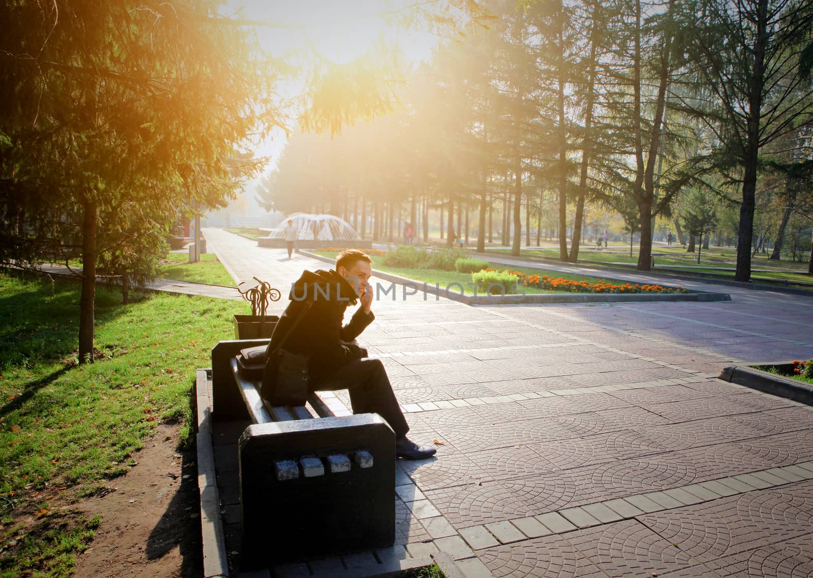 Toned photo of Young Man with Mobile Phone at the Autumn Park