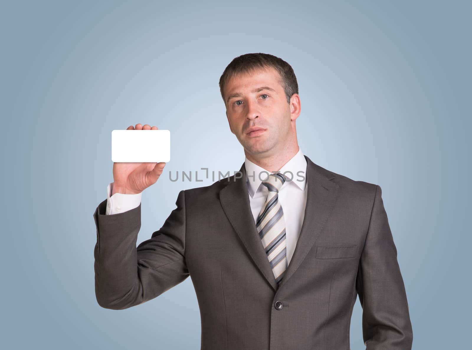 Businessman in suit hold empty white card in hand. Blue background