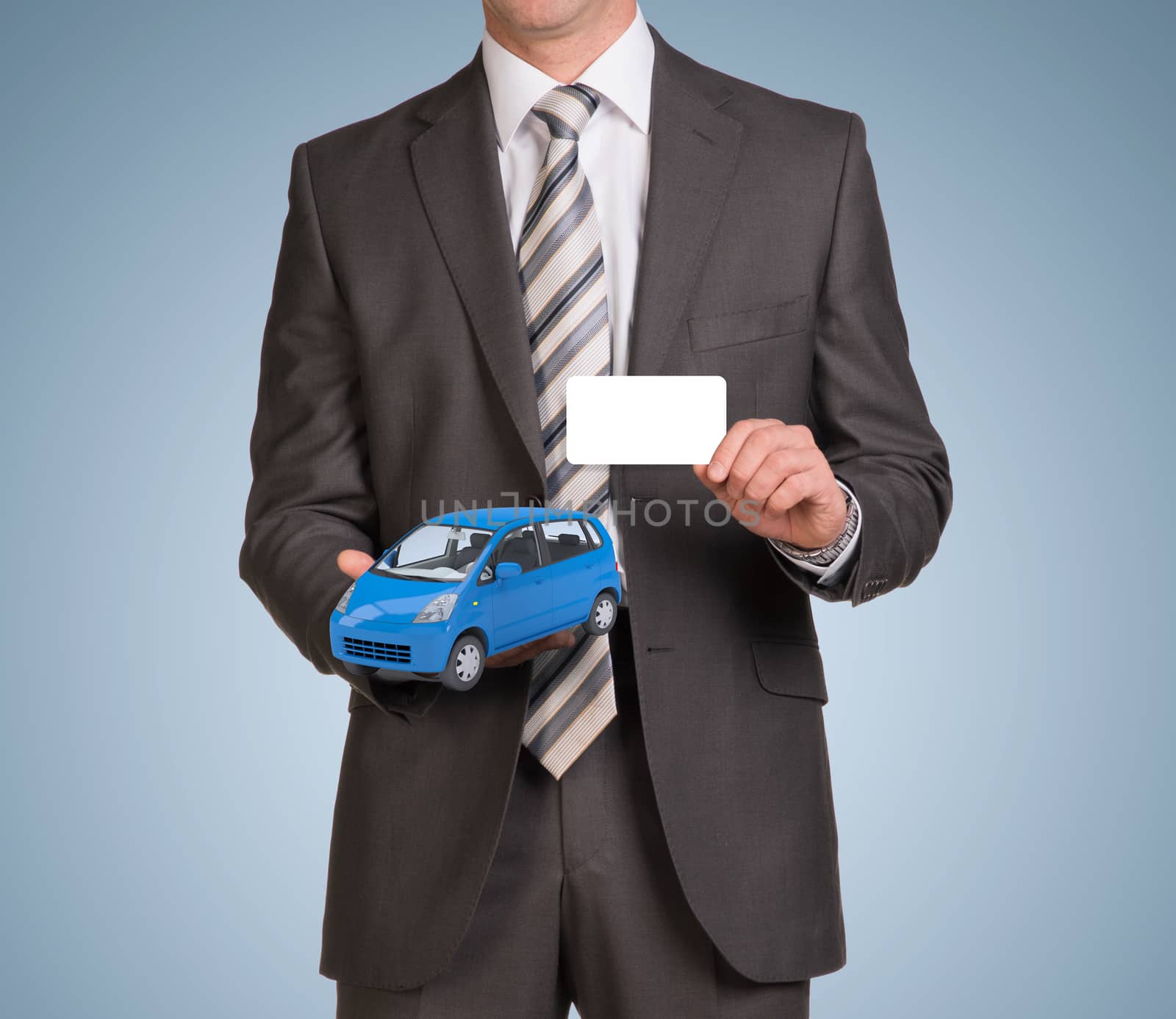 Businessman hold empty card and small blue car by cherezoff