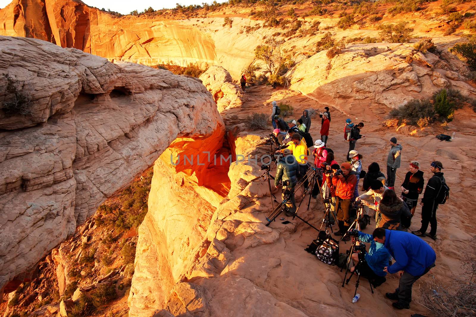 Photographers and tourists watching sunrise at  Mesa Arch, Canyo by donya_nedomam