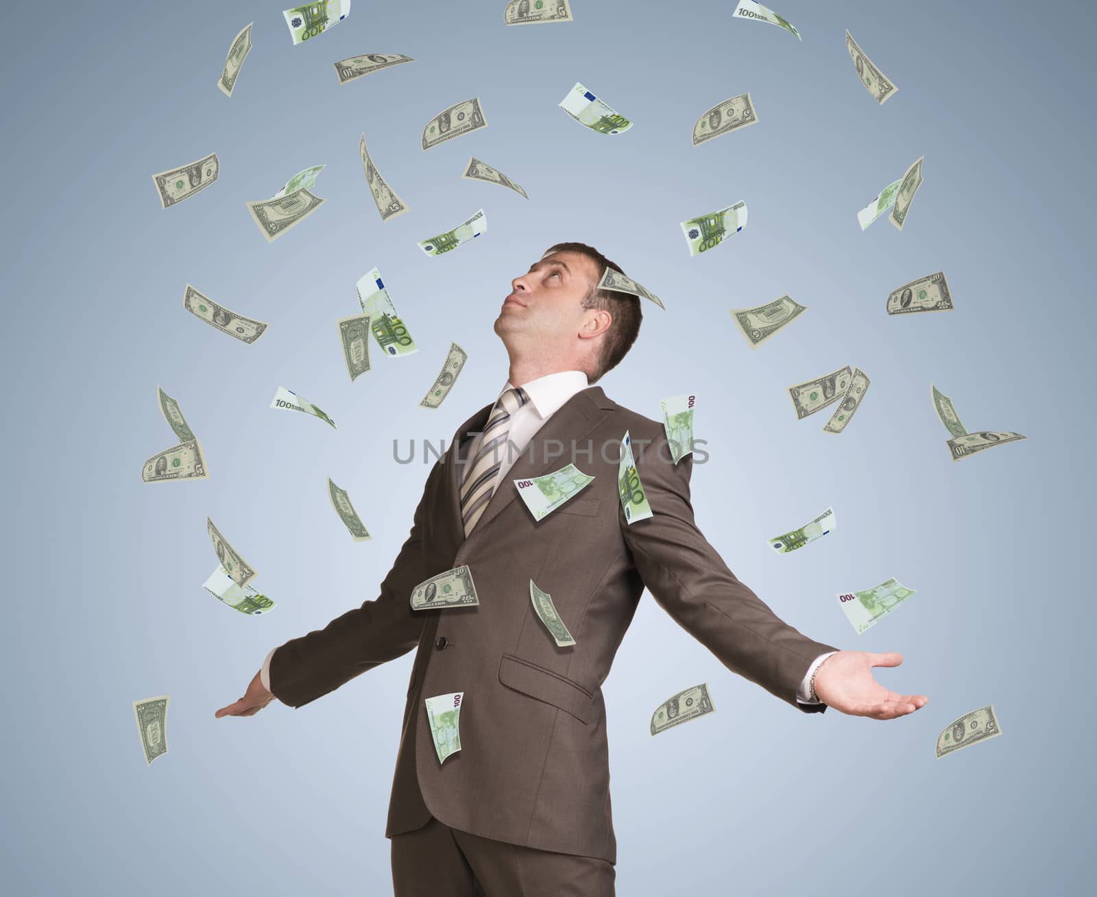 Businessman in suit spread his arms and looking up. Money fall from above