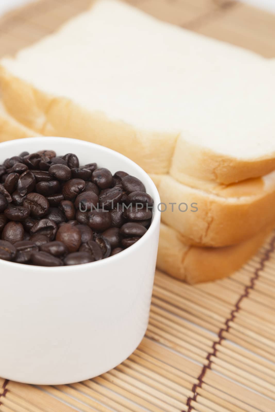 Bread plate and cup with coffee beans.on table wooden pack-shot in studio.