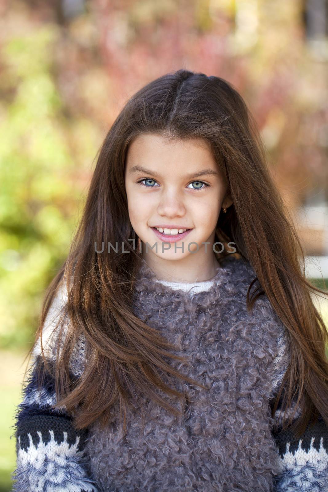 Close up portrait of a beautiful nine year old little girl in autumn park