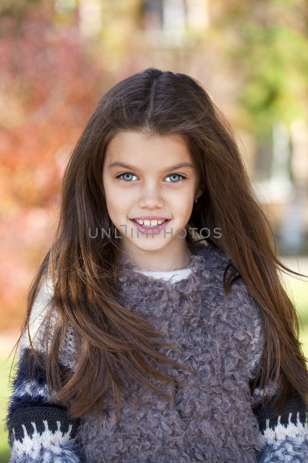 Close up portrait of a beautiful nine year old little girl in autumn park