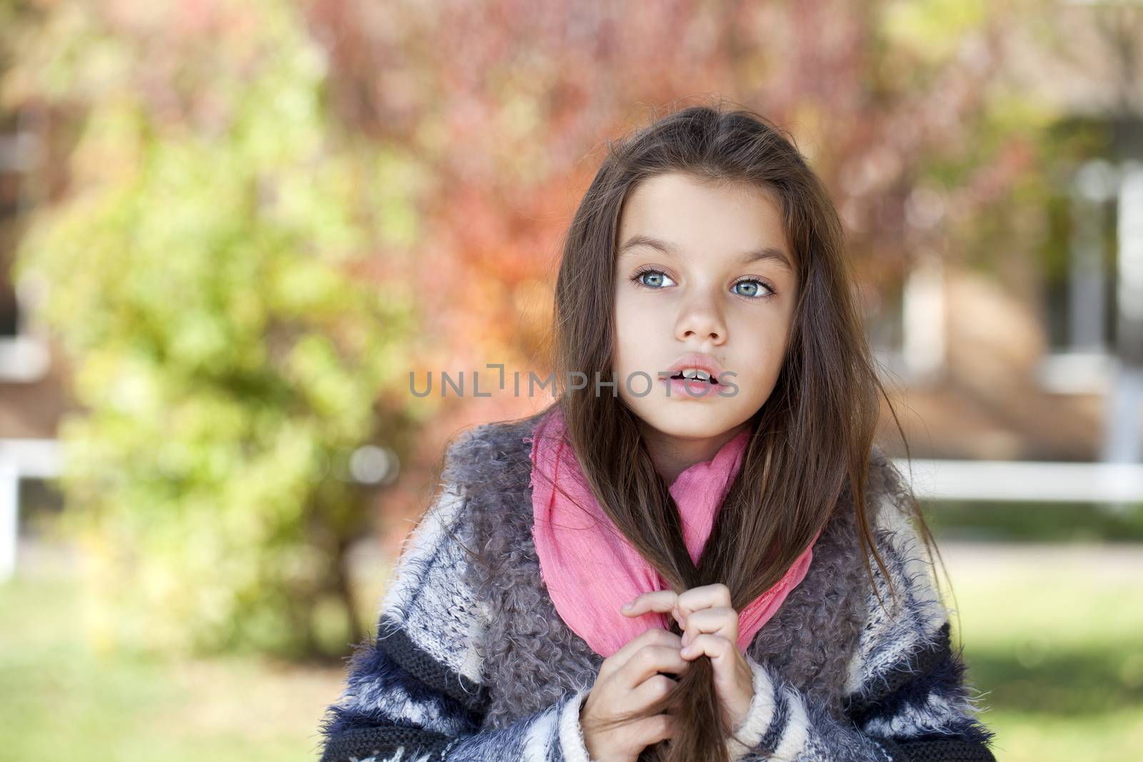 Close up portrait of a beautiful nine year old little girl in autumn park