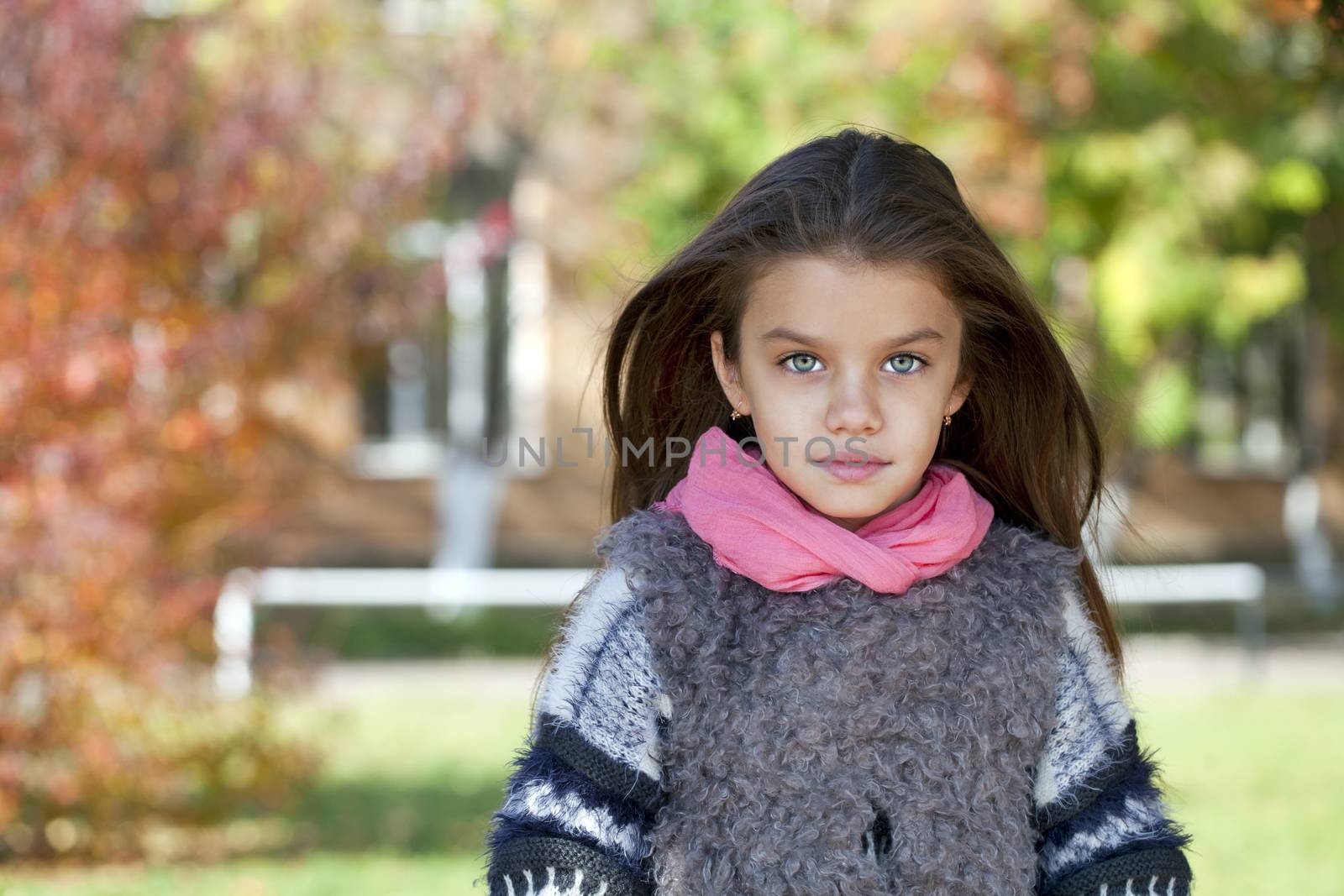 Close up portrait of a beautiful nine year old little girl in autumn park