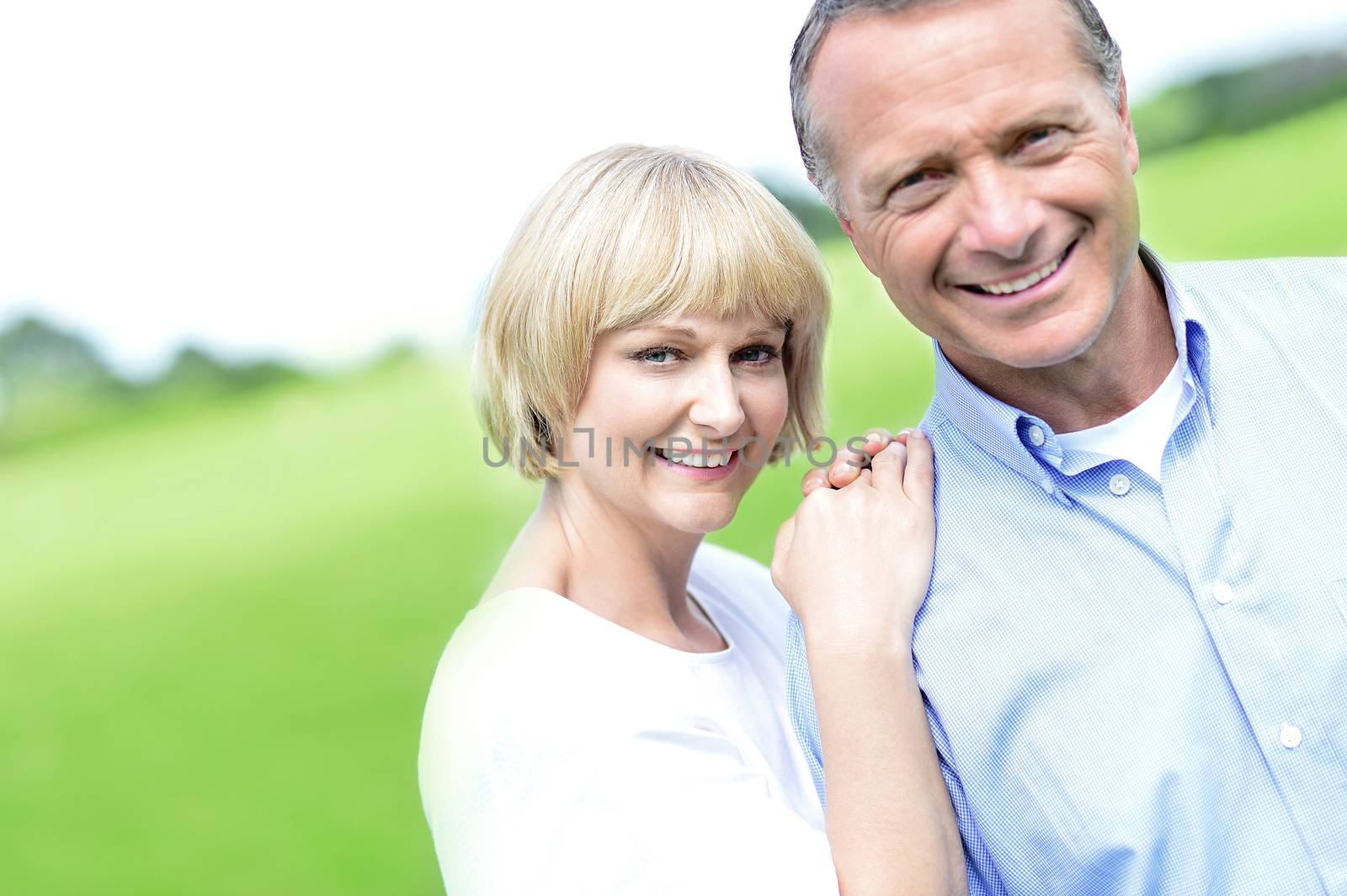 Happy middle aged couple posing together at outdoors