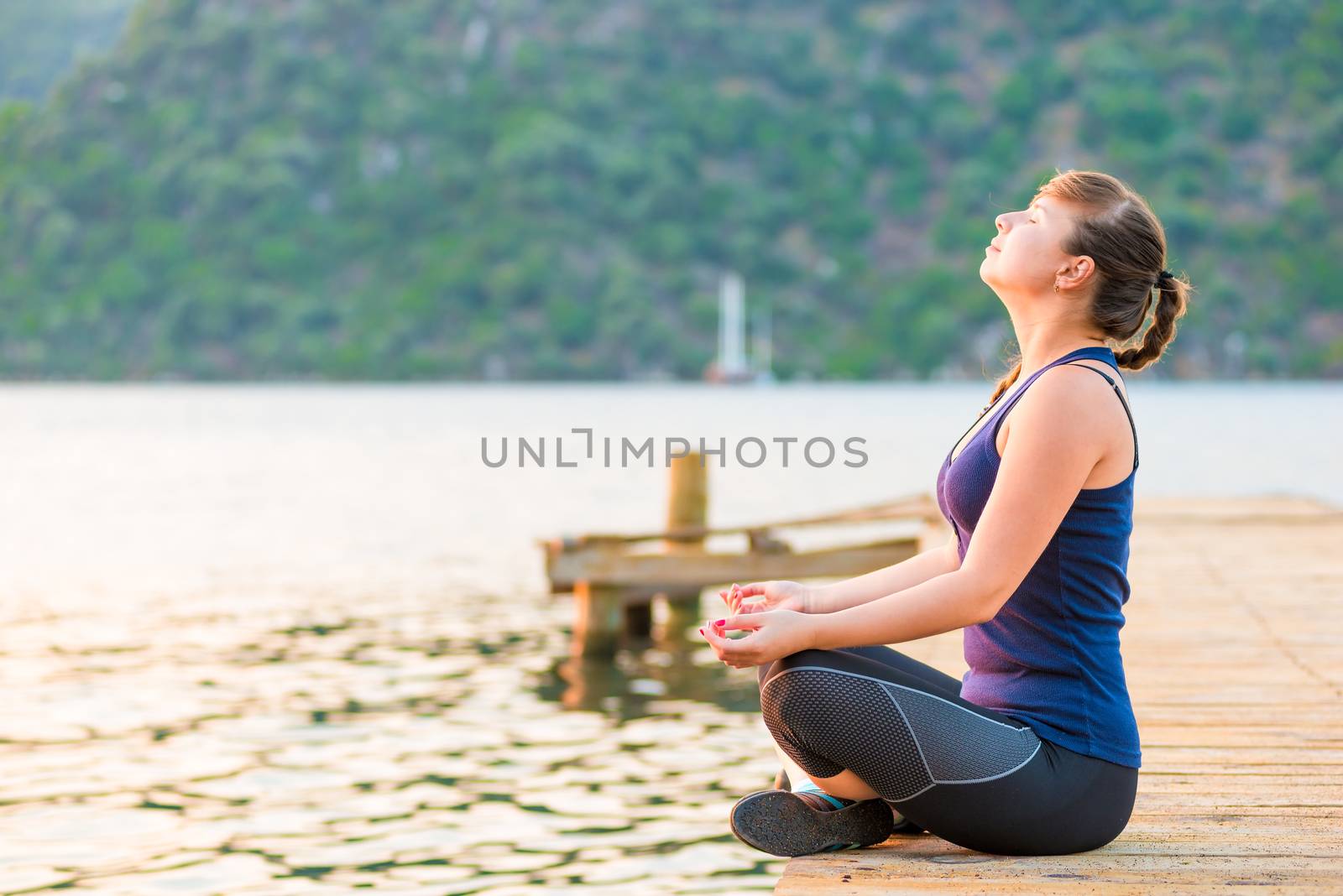 satisfied athlete relaxes on a pier in the morning