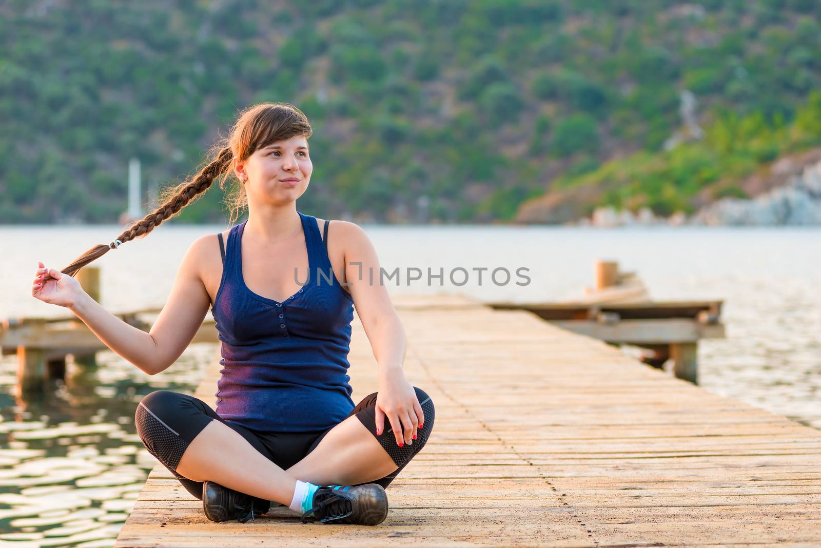 cute charming young girl in sportswear on a pier