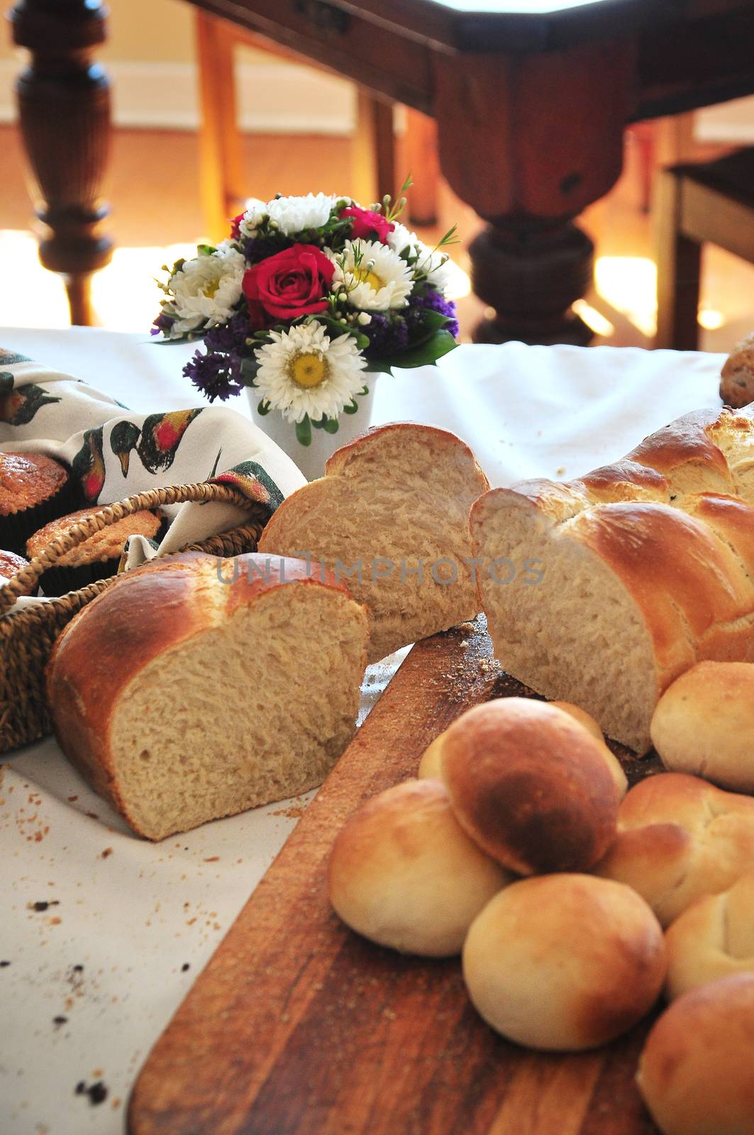 A display of fresh home baked white bread, and buns on a cutting board. Hospitality or Home Industry.