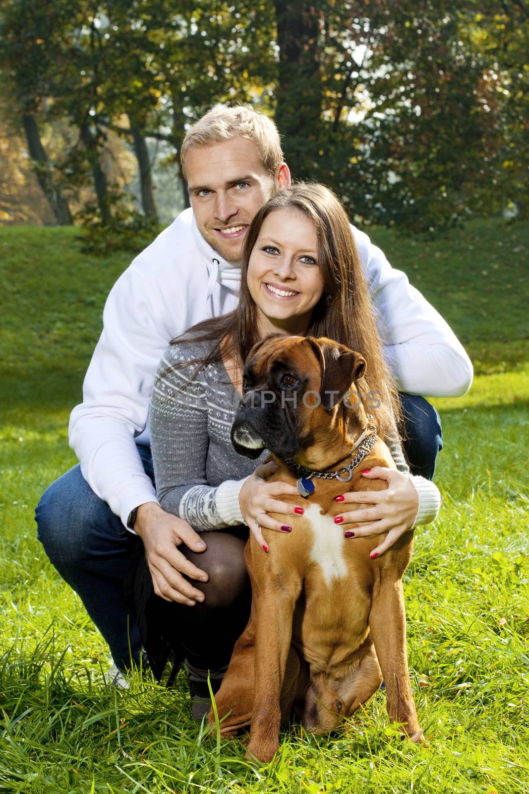 Portrait of a Happy Young Couple with their Dog in the Park.