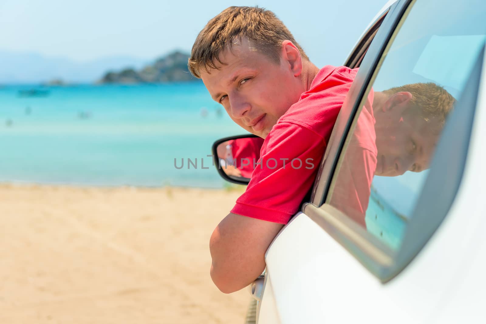 a man in a car near the sea