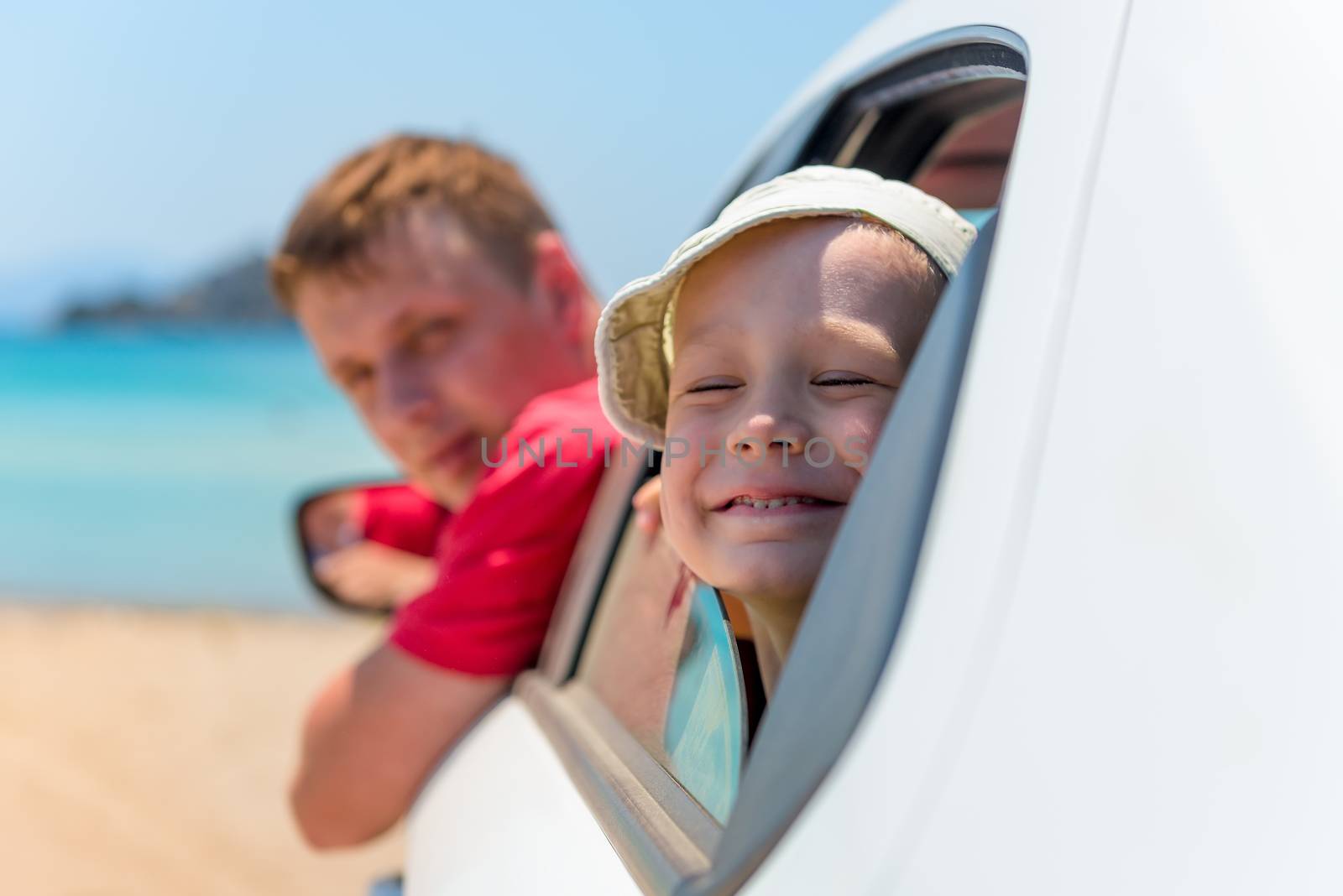 father and son look out car windows