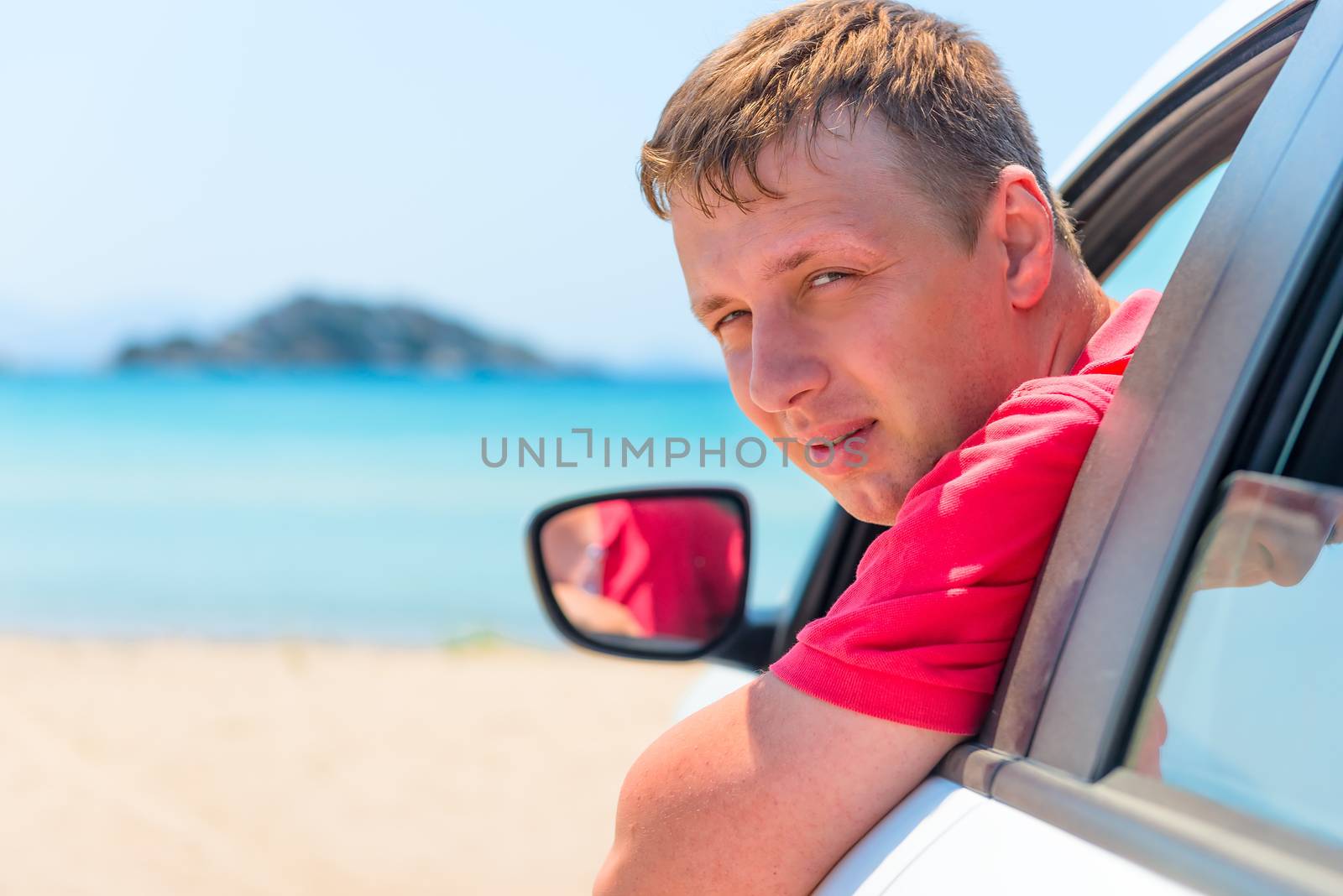 handsome man looking out the window of the car, shot near the sea