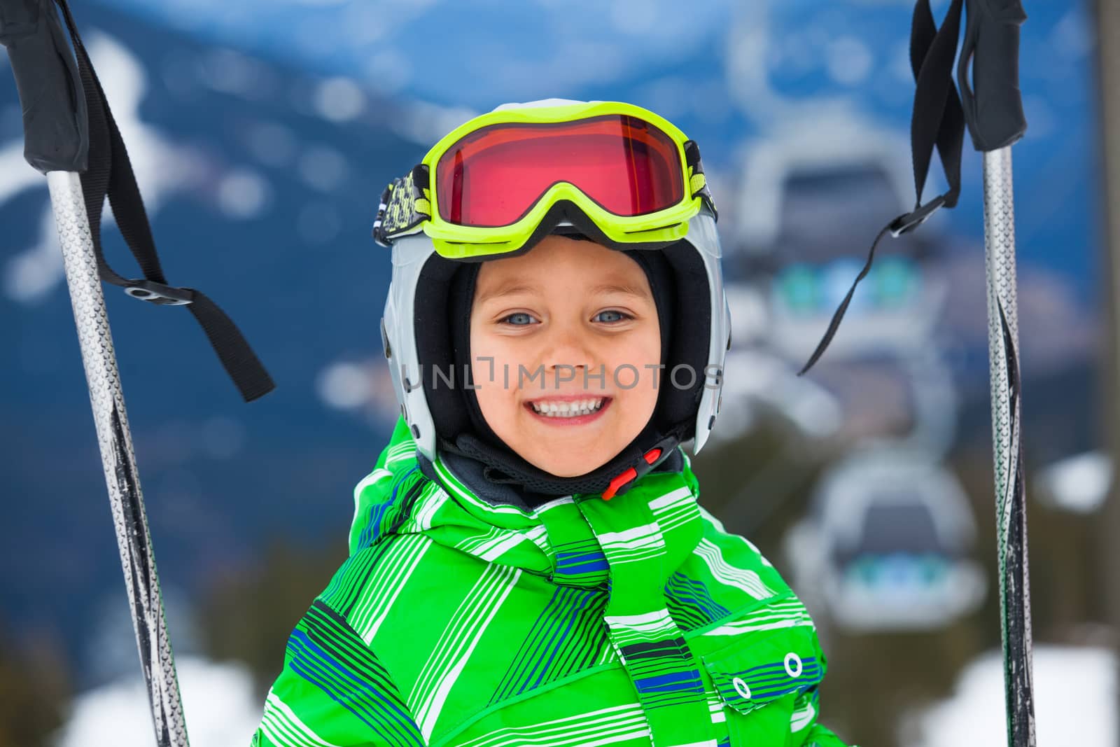 Skier, skiing, winter sport - portrait of Cute happy skier boy in a winter ski resort.