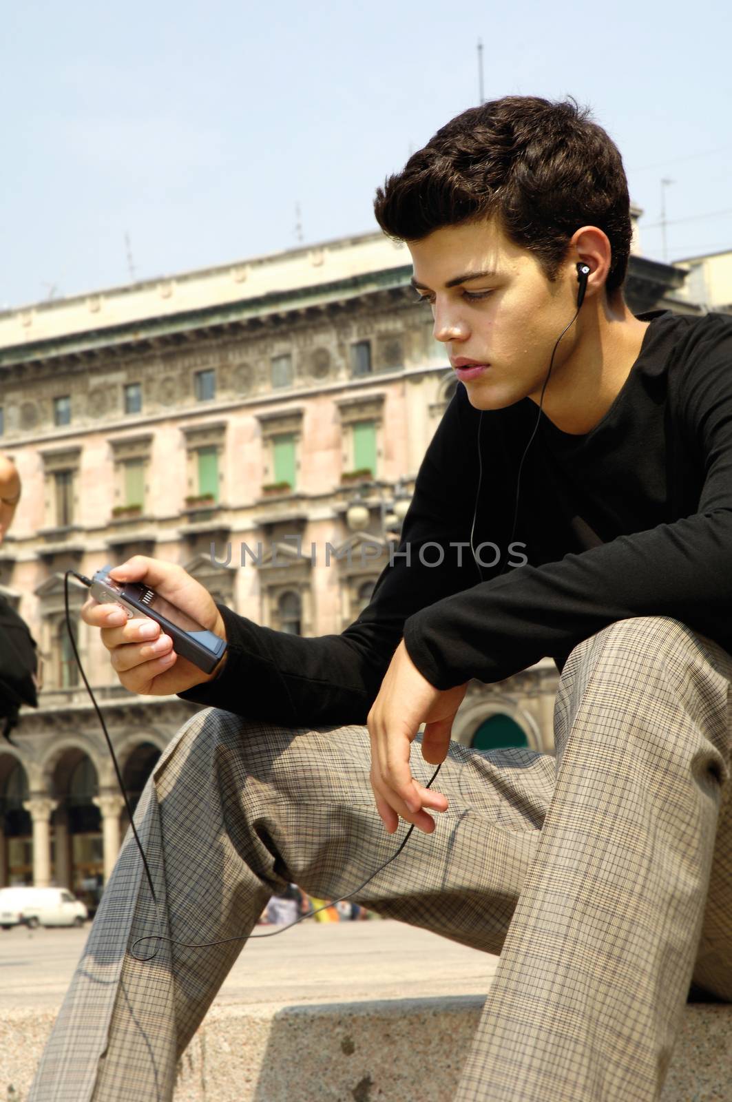 handsome young guy listening to favorite songs on the mp3 player 