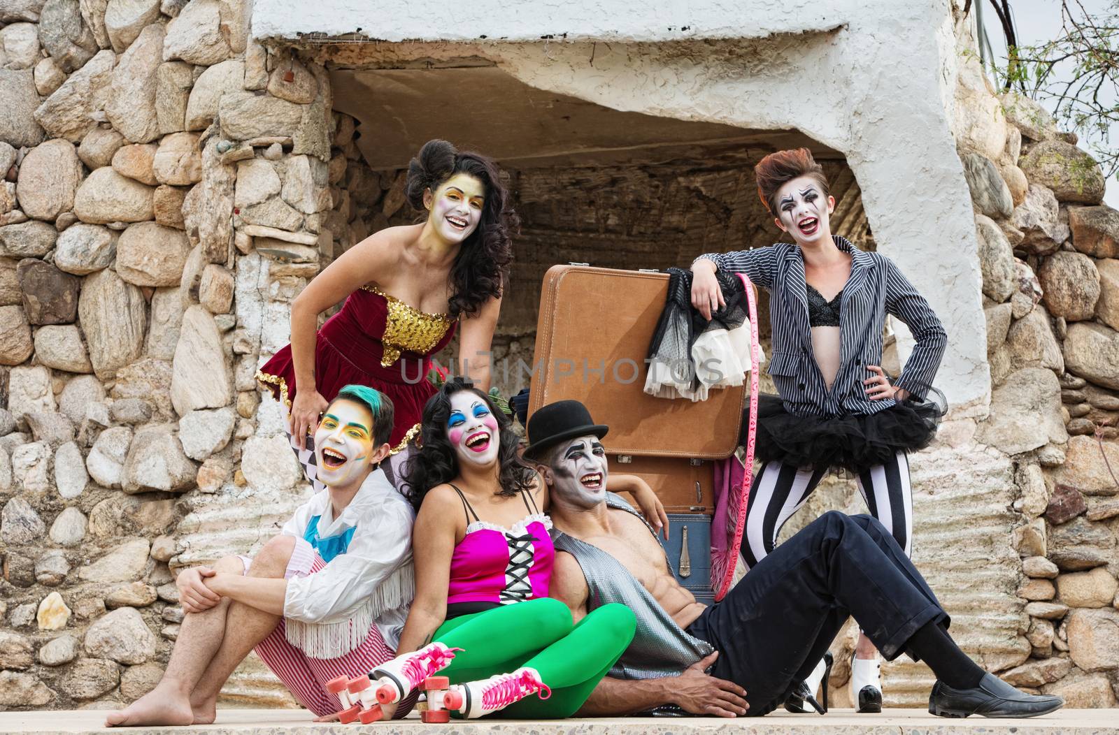 Lauging ensemble of bizarre circus clowns on stage