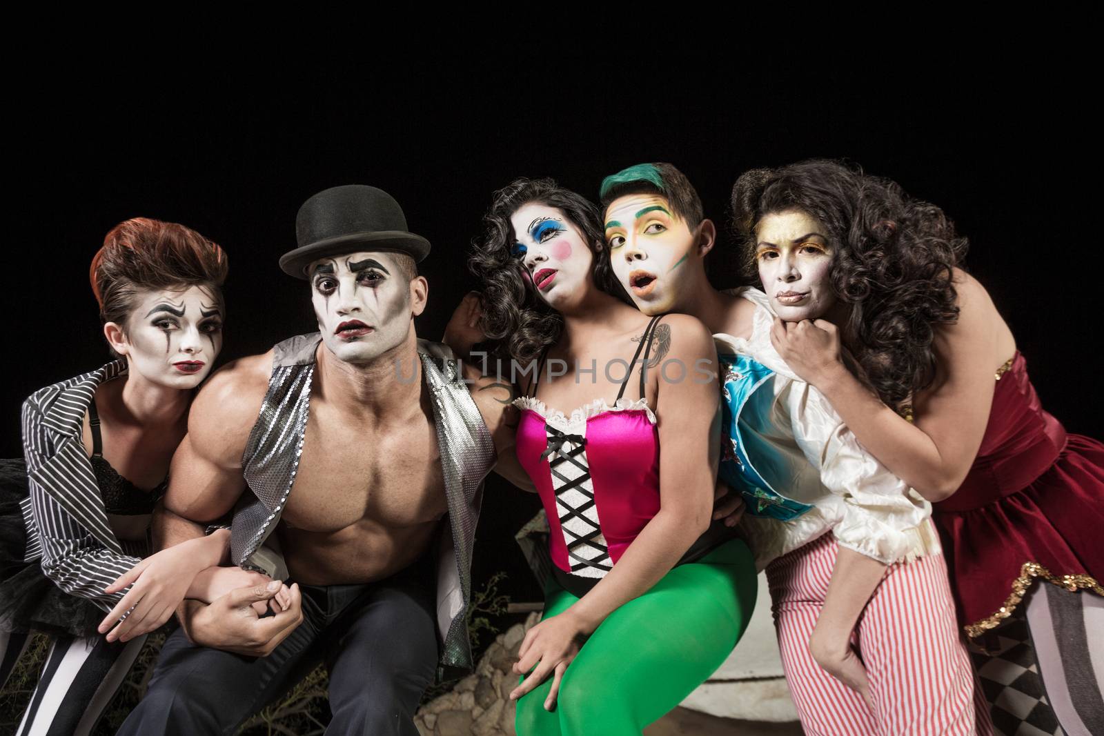 Five serious cirque clowns on theater stage