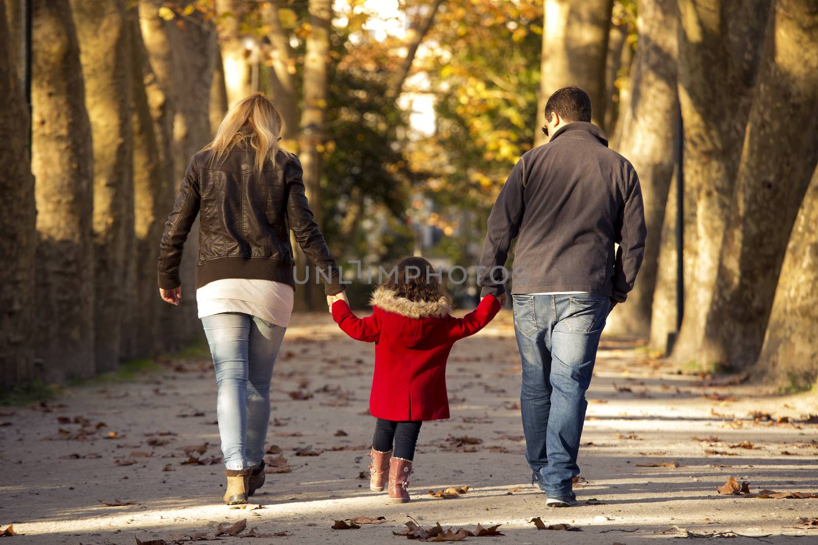 Outdoor portrait of a happy family walking together and enjoying the fall season