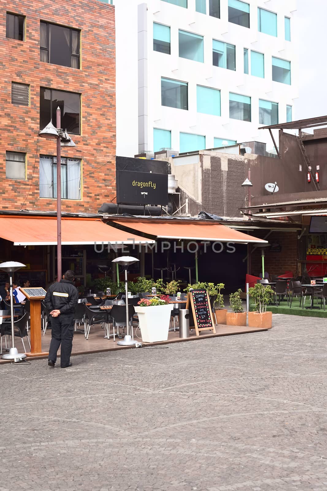 QUITO, ECUADOR - AUGUST 6, 2014: Outdoor sitting area of the Coffee Bar and the Dragonfly restaurant-cocktail room next to it on Plaza Foch in the tourist district La Mariscal on August 6, 2014 in Quito, Ecuador. Plaza Foch is situated at the intersection of the streets Reina Victoria and Mariscal Foch, around which many hostels, bars, restaurants and other facilities for tourism and entertainment are located. 