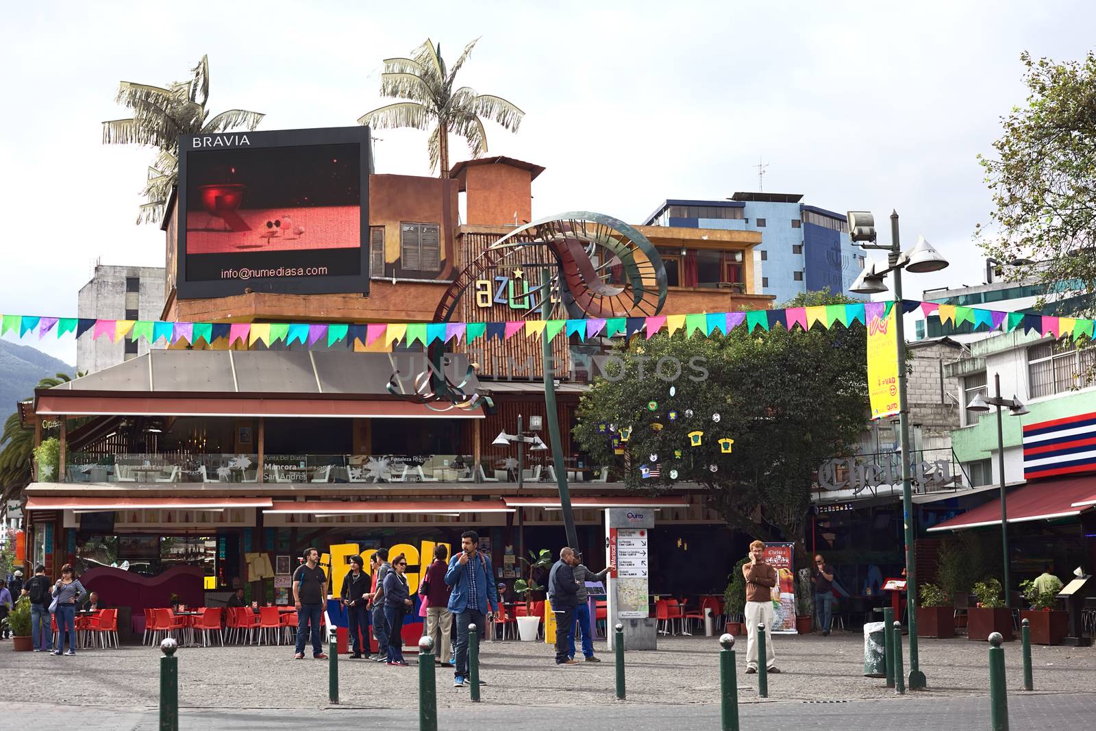 QUITO, ECUADOR - AUGUST 6, 2014: Unidentified people standing on Plaza Foch in front of the Azuca Latin Bistro and Chelsea restaurant-bar-lounge in the tourist district La Mariscal on August 6, 2014 in Quito, Ecuador. Plaza Foch is situated at the intersection of the streets Reina Victoria and Mariscal Foch, around which many hostels, bars, restaurants and other facilities for tourism and entertainment are located. 