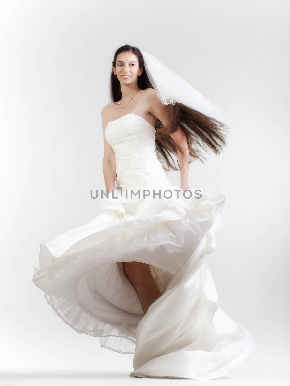 portrait od a bride with long dark hair in wedding dress - isolated on gray