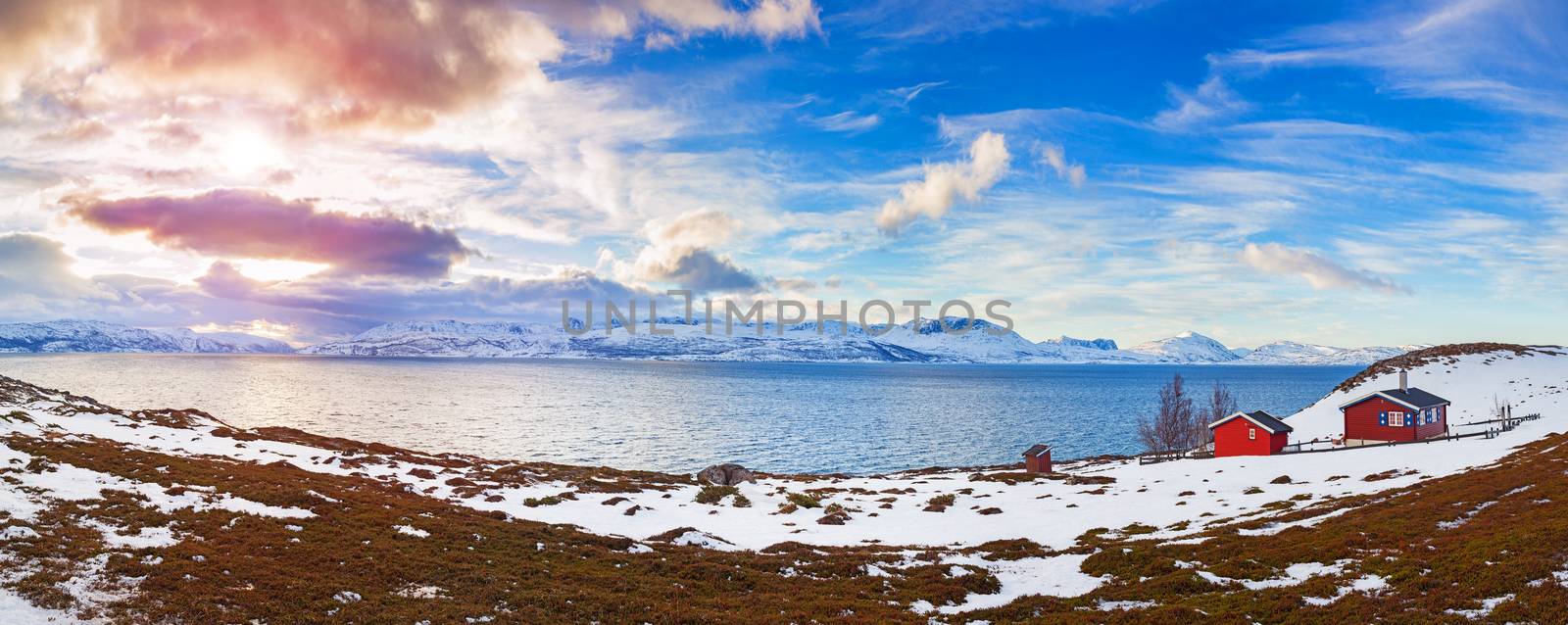 Winter in Norway - mountains with red house and the ocean. Panorama