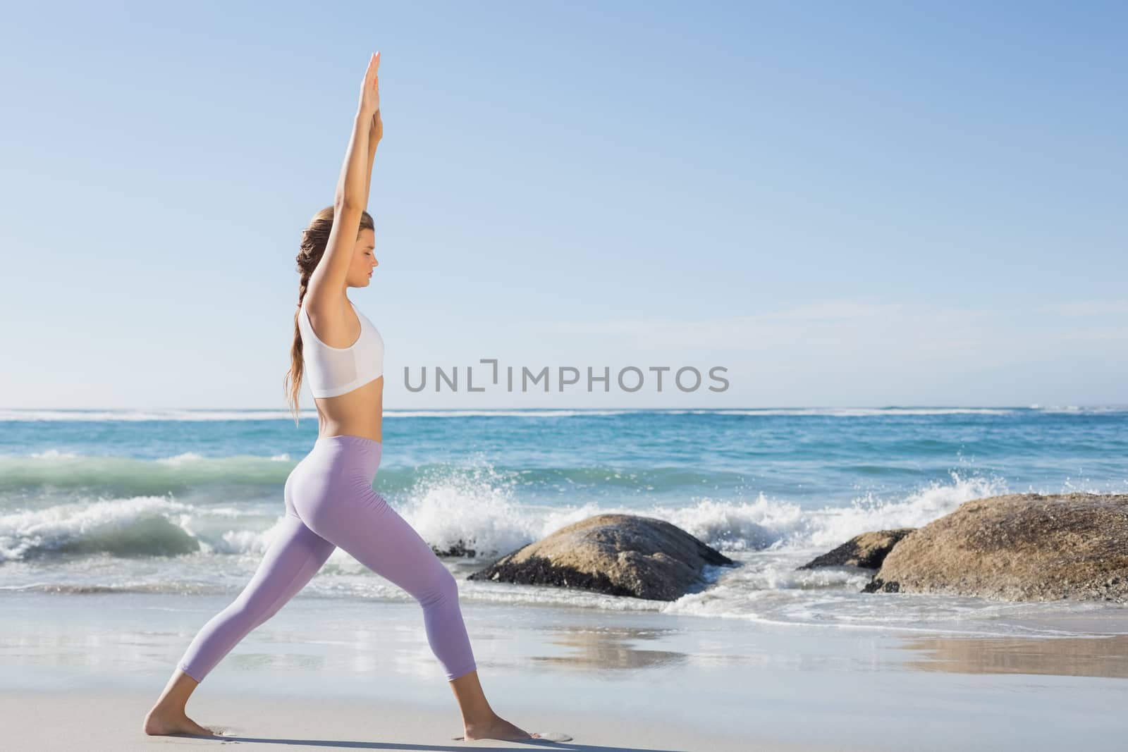 Sporty blonde stretching on the beach by Wavebreakmedia