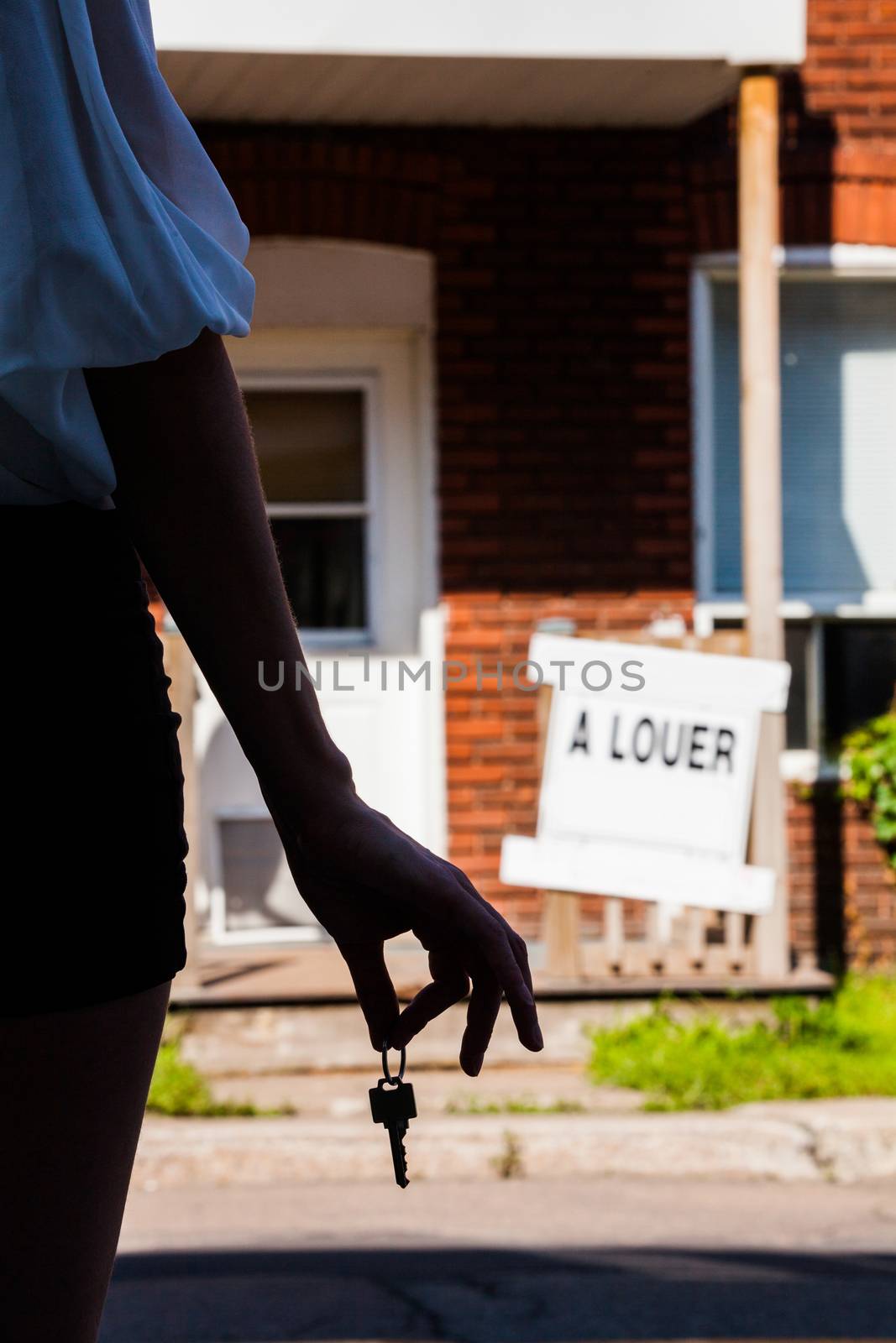 Young Woman standing in front of her new apartment by aetb