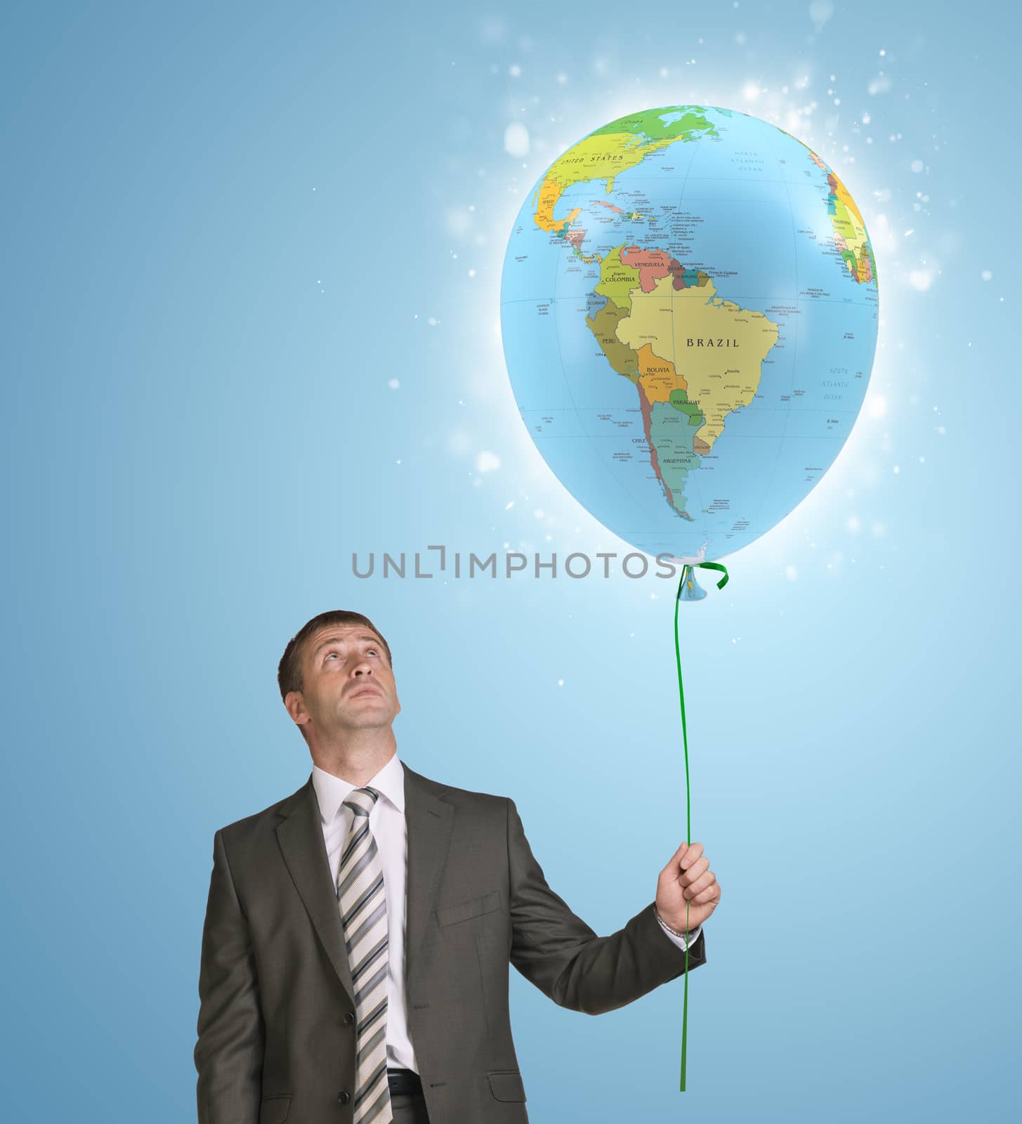 Businessman in suit holding balloon with the image of world map. Blue background