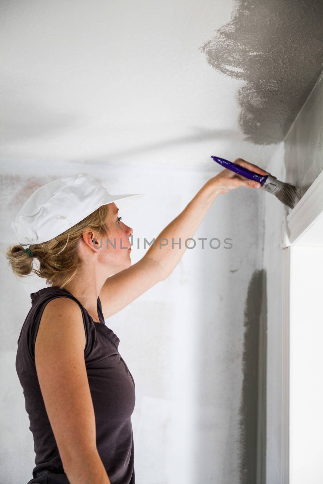 Woman Painting the Edges of the Ceiling with Paintbrush
